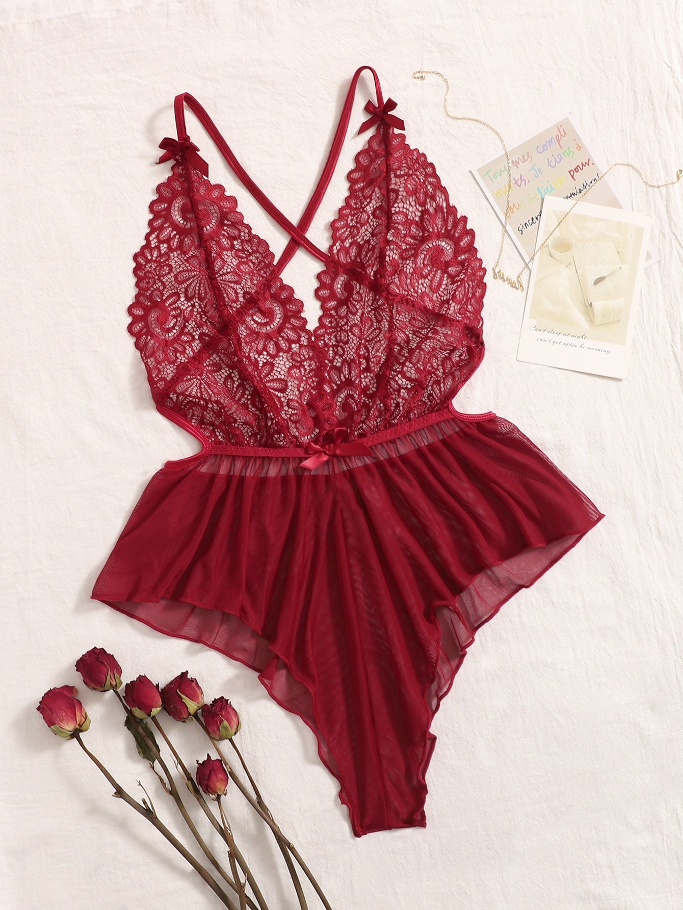 Sheer mesh teddy bodysuit lingerie with contrast lace detailing, spaghetti straps, criss-cross back, backless design, bow accent, and V-string cut.