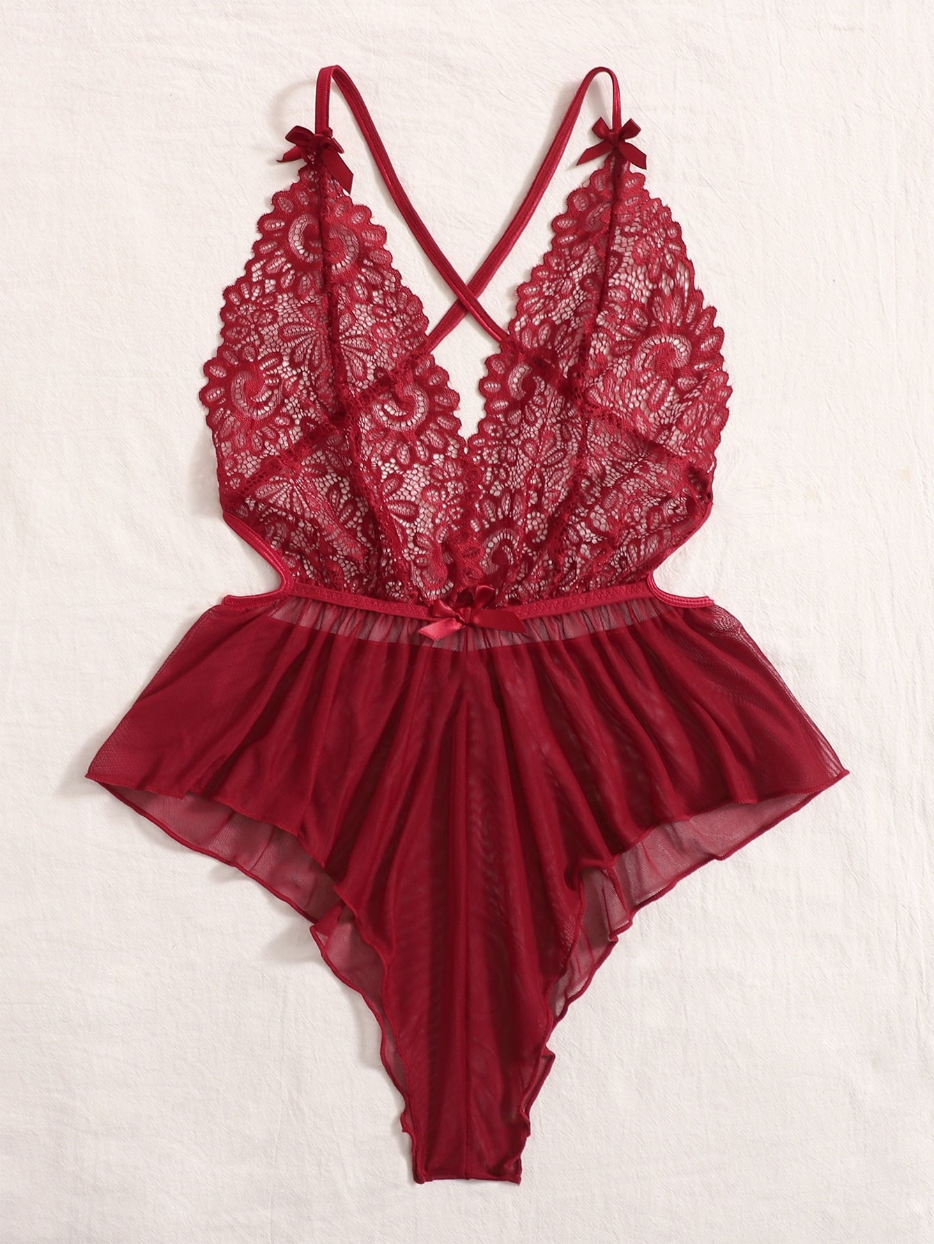 Sheer mesh teddy bodysuit lingerie with contrast lace detailing, spaghetti straps, criss-cross back, backless design, bow accent, and V-string cut.
