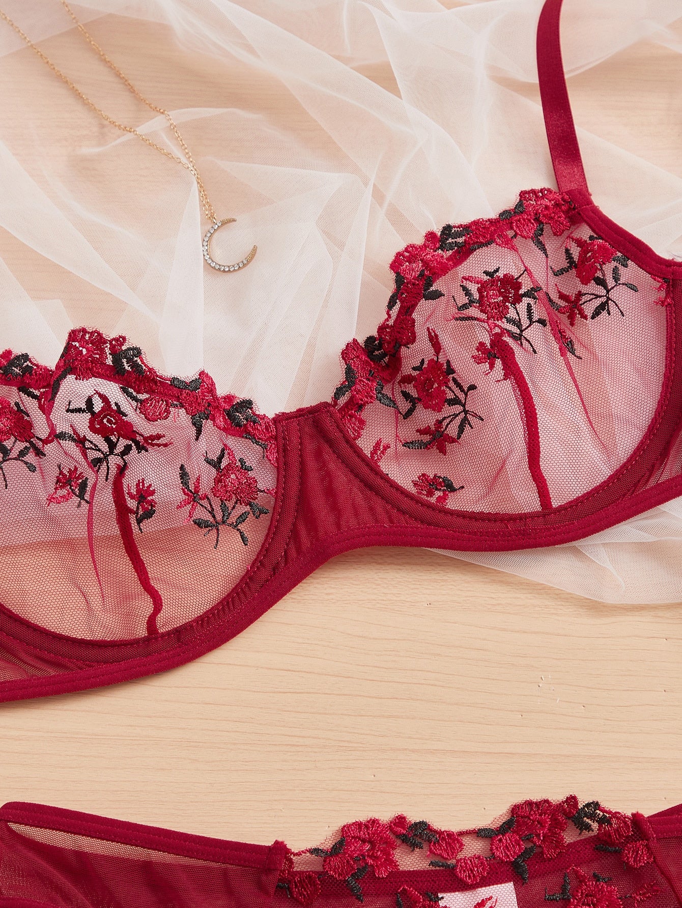 Two-piece women’s lingerie set with embroidered sheer mesh underwire balconette bra and matching mid-rise thong, featuring adjustable straps and slight stretch. Available in Black and Burgundy.