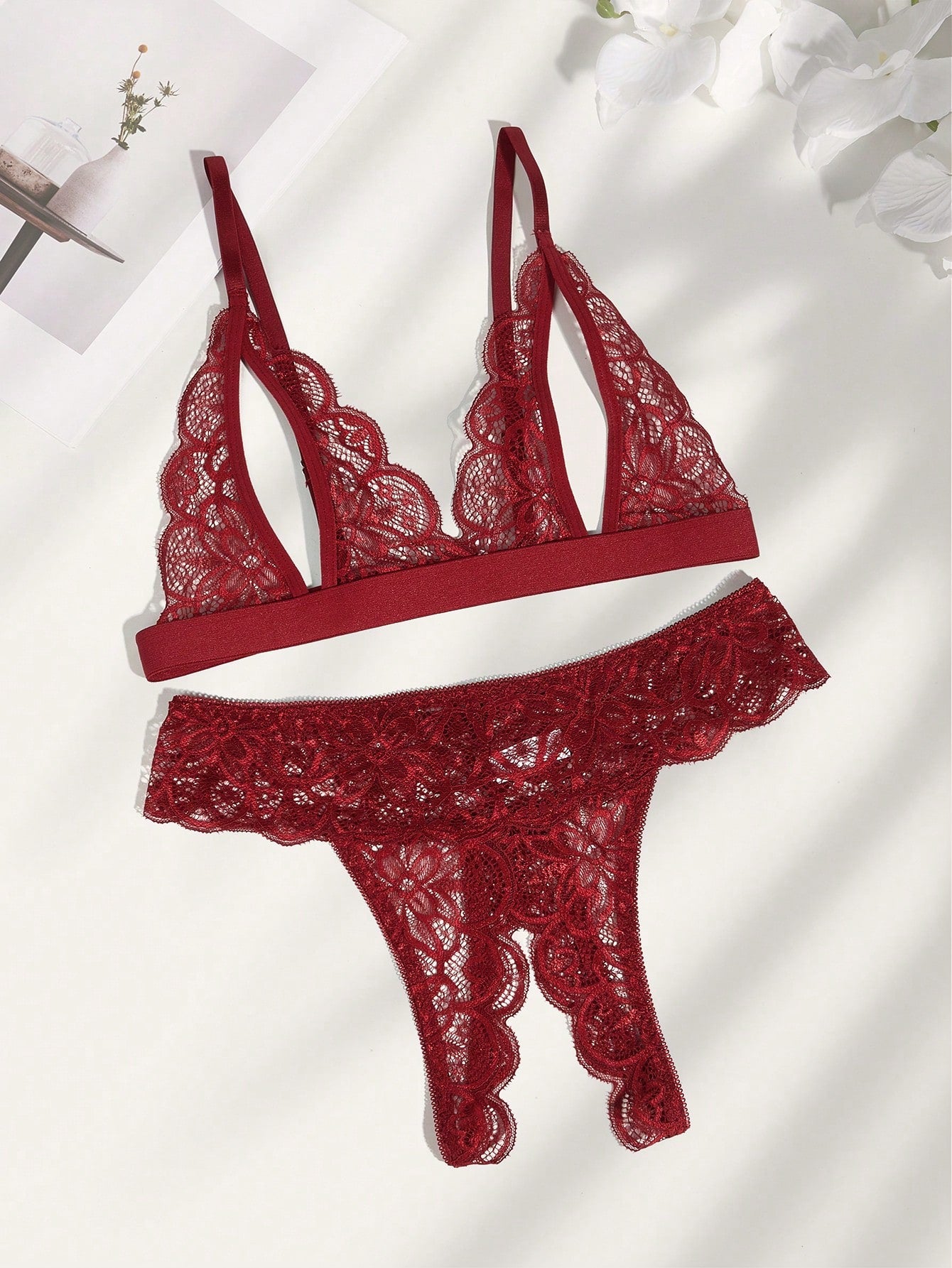 Burgundy floral lace lingerie set with scallop trim, cut-out detail, adjustable spaghetti straps, a bralette-style top, and mid-rise thong bottoms.