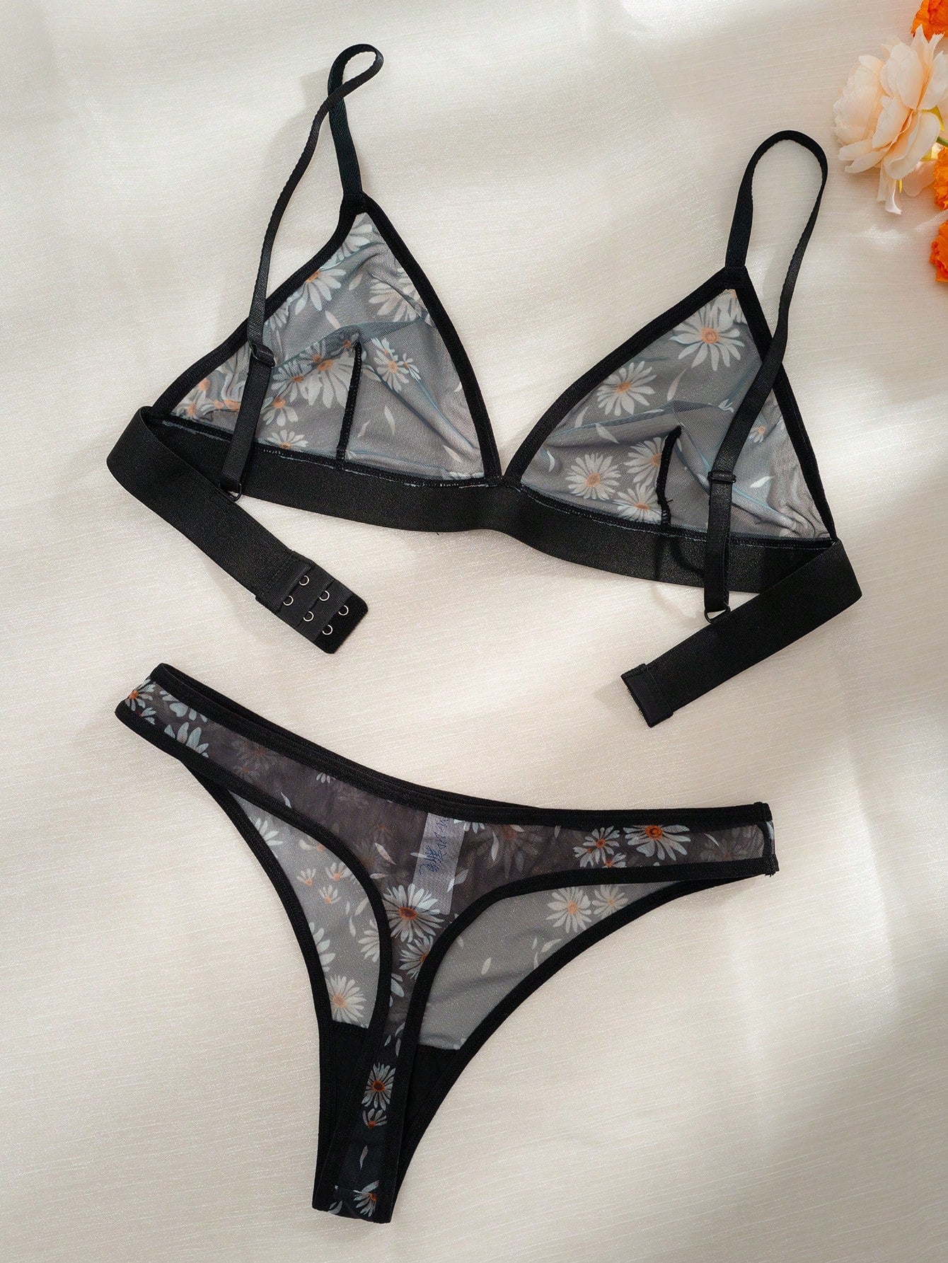 Women’s 2-piece lingerie set featuring a wireless bralette and matching low-rise G-string thong with adjustable straps, contrast binding, and an all-over multicolor animal-inspired print.