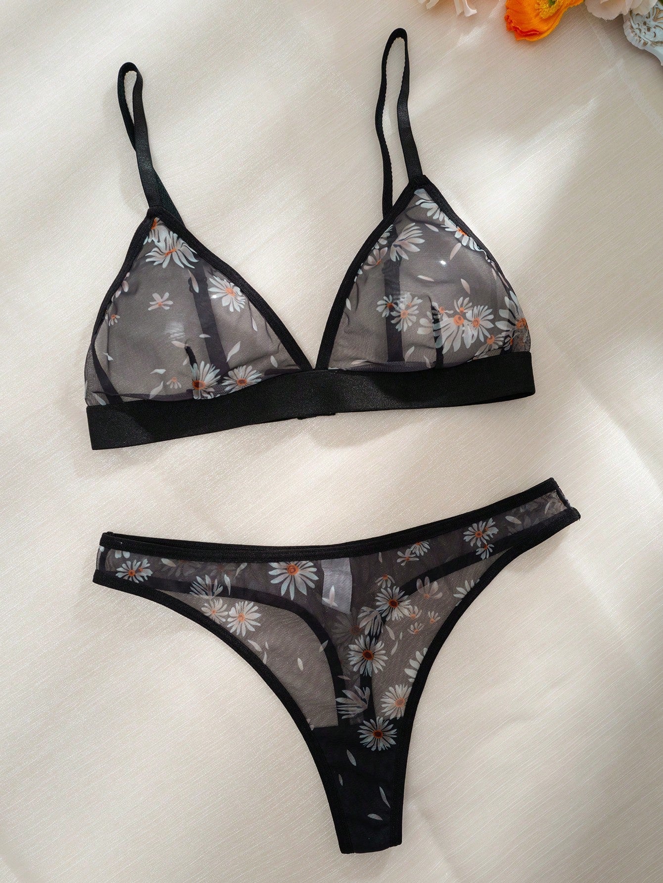 Women’s 2-piece lingerie set featuring a wireless bralette and matching low-rise G-string thong with adjustable straps, contrast binding, and an all-over multicolor animal-inspired print.