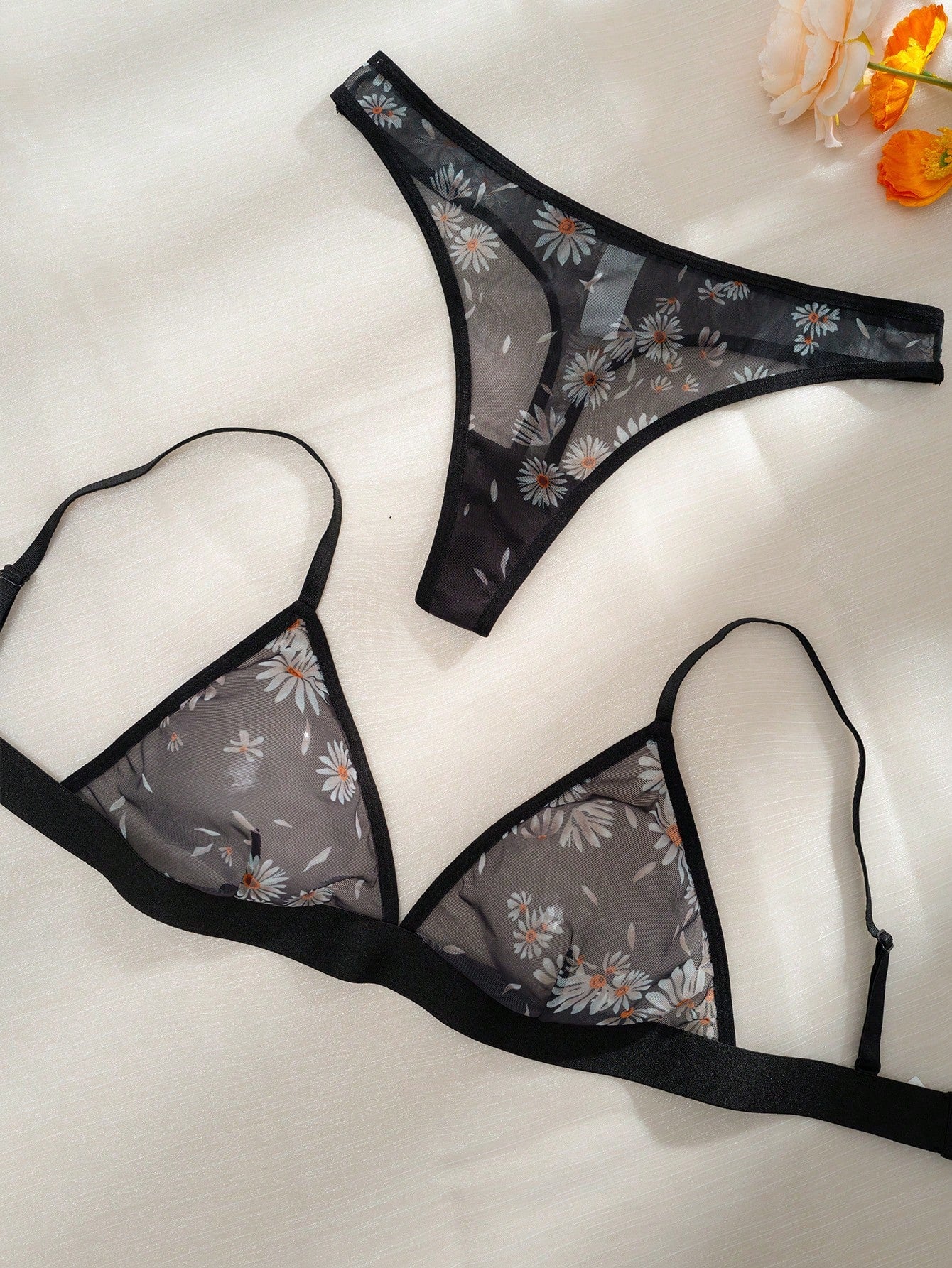 Women’s 2-piece lingerie set featuring a wireless bralette and matching low-rise G-string thong with adjustable straps, contrast binding, and an all-over multicolor animal-inspired print.