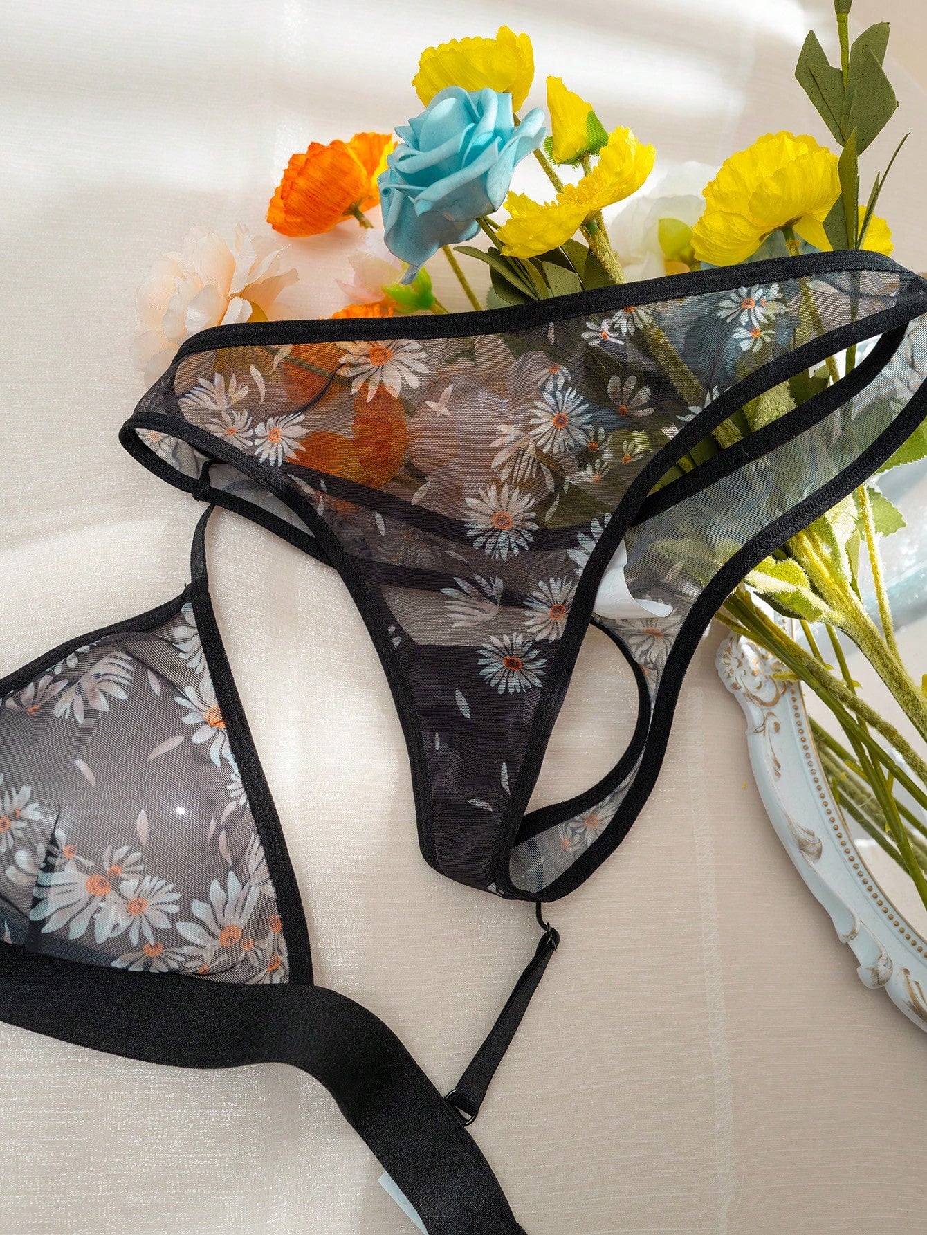 Women’s 2-piece lingerie set featuring a wireless bralette and matching low-rise G-string thong with adjustable straps, contrast binding, and an all-over multicolor animal-inspired print.