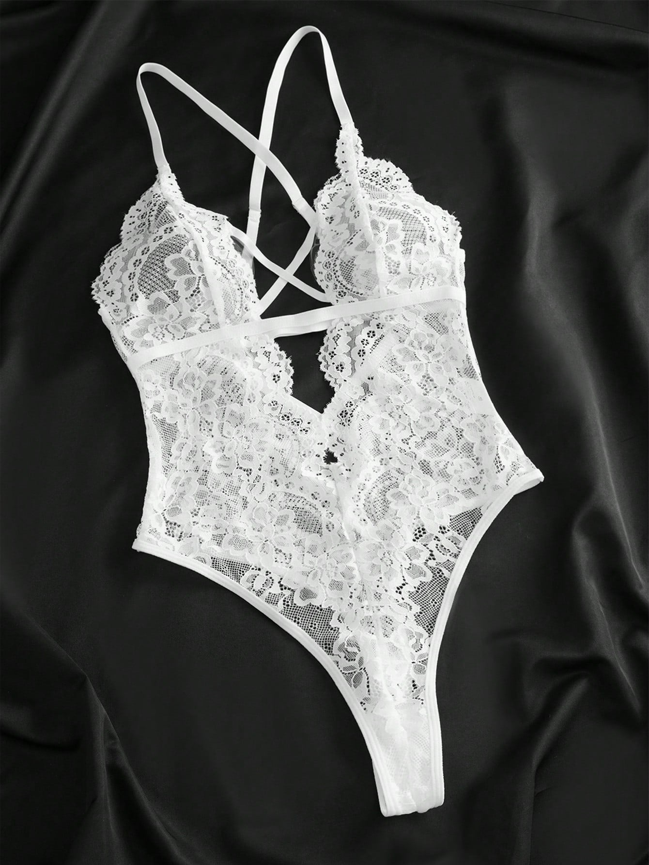 Women’s lace bodysuit featuring a criss-cross back, backless design, spaghetti straps, cut-out accents, and scalloped trim.