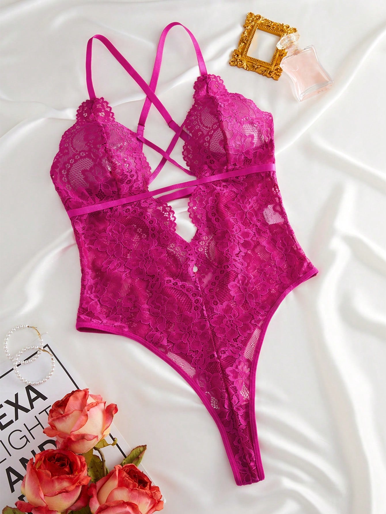 Women’s lace bodysuit featuring a criss-cross back, backless design, spaghetti straps, cut-out accents, and scalloped trim.