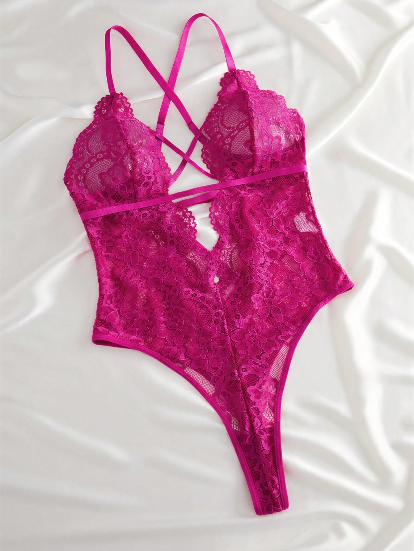 Women’s lace bodysuit featuring a criss-cross back, backless design, spaghetti straps, cut-out accents, and scalloped trim.