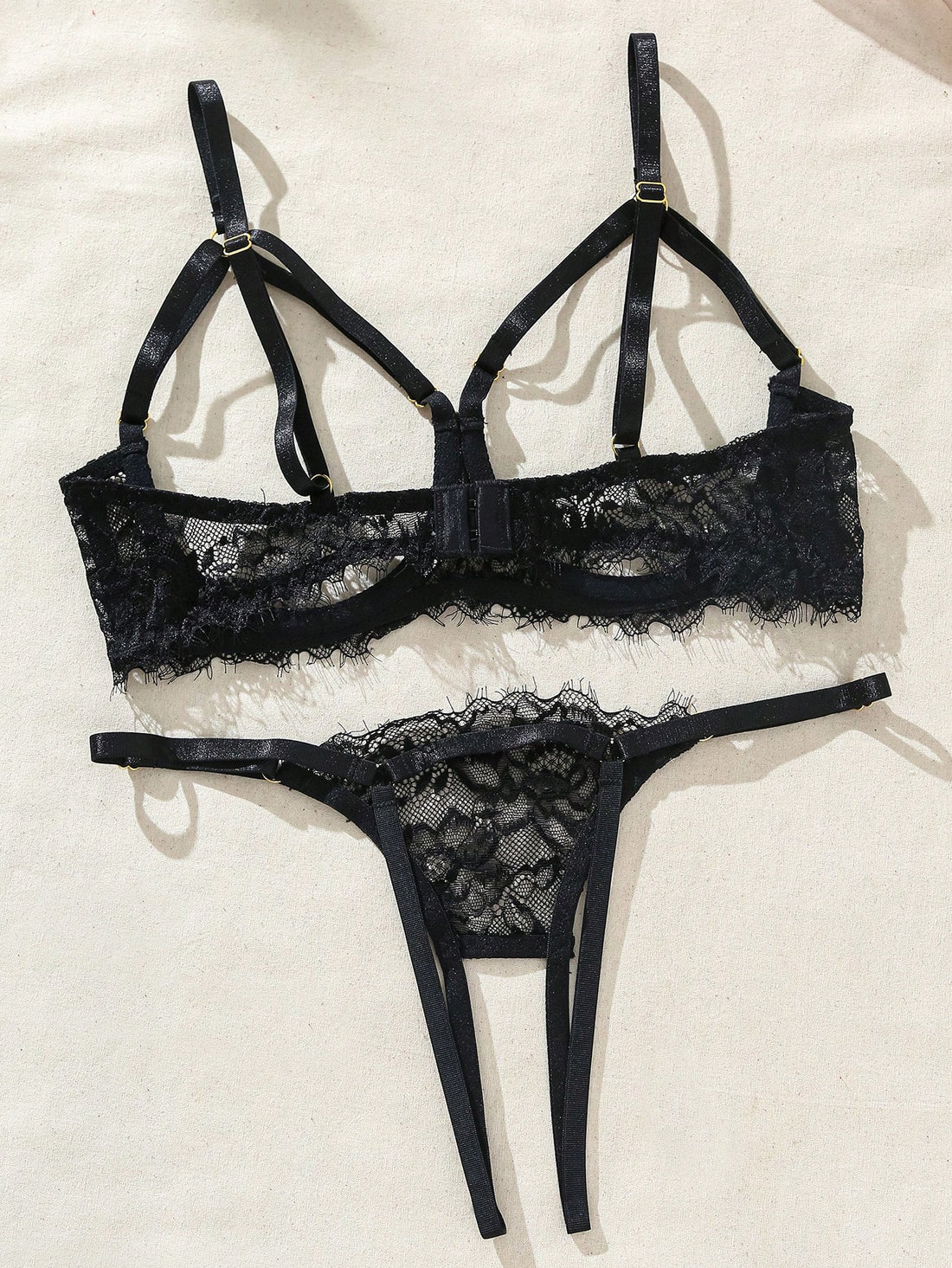 Two-piece goth-style floral lace lingerie set featuring a triangle bra with adjustable spaghetti straps, cut-out harness detailing, and a matching mid-rise thong.