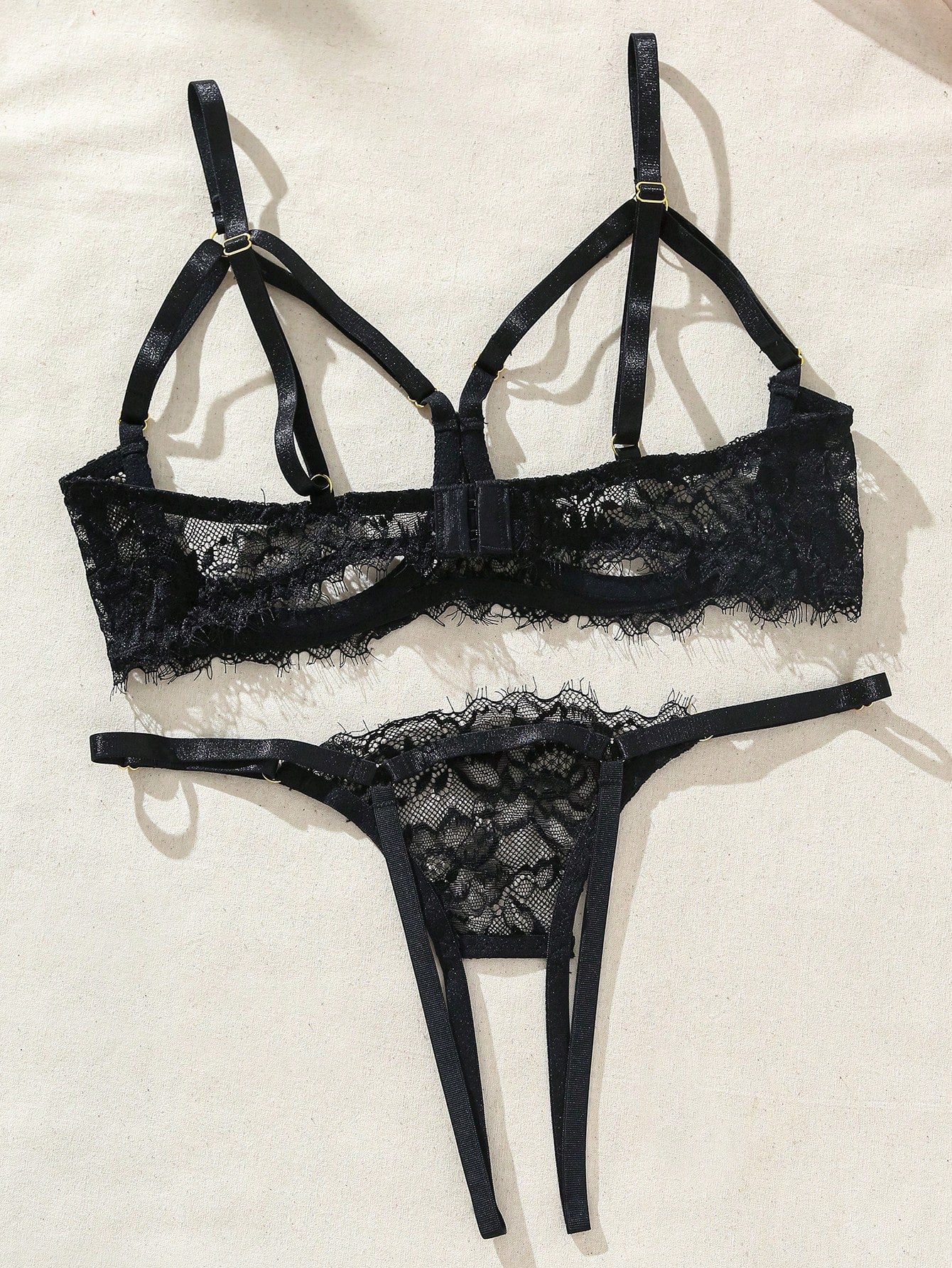 Two-piece goth-style floral lace lingerie set featuring a triangle bra with adjustable spaghetti straps, cut-out harness detailing, and a matching mid-rise thong.