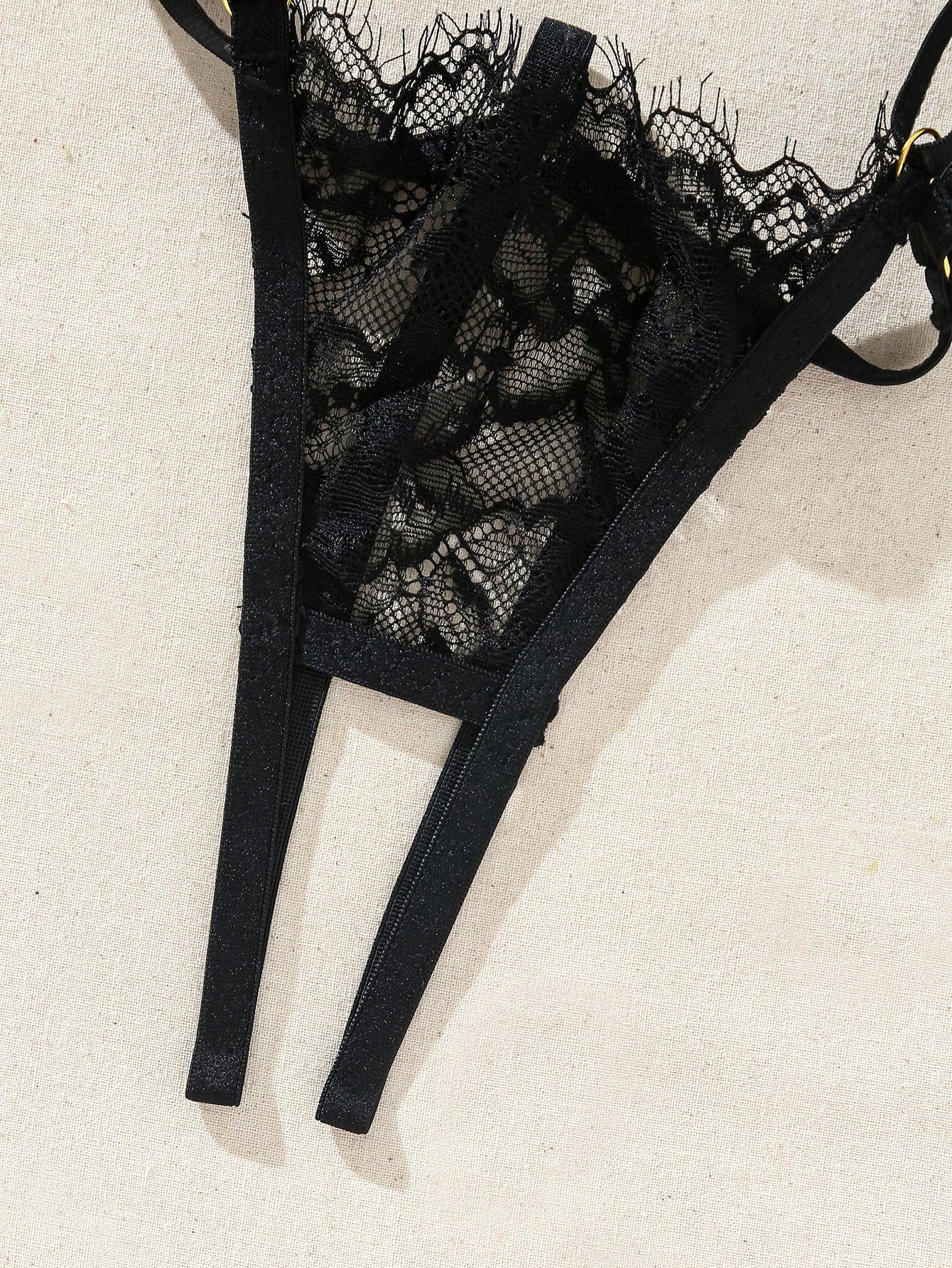Two-piece goth-style floral lace lingerie set featuring a triangle bra with adjustable spaghetti straps, cut-out harness detailing, and a matching mid-rise thong.