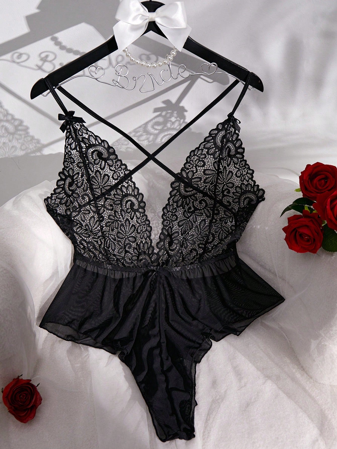 Sheer mesh teddy bodysuit lingerie with contrast lace detailing, spaghetti straps, criss-cross back, backless design, bow accent, and V-string cut.