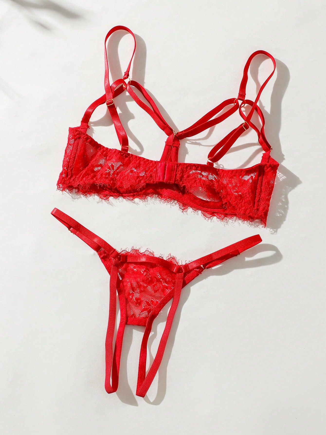 Two-piece goth-style floral lace lingerie set featuring a triangle bra with adjustable spaghetti straps, cut-out harness detailing, and a matching mid-rise thong.