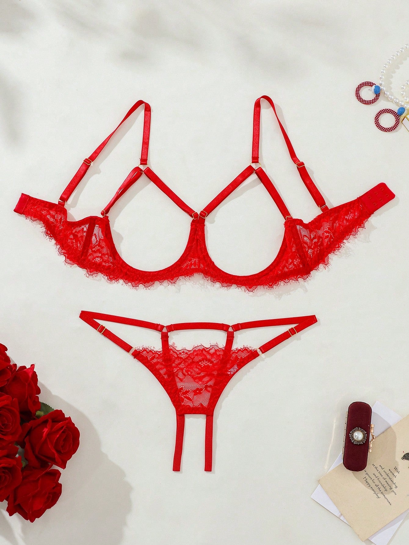 Two-piece goth-style floral lace lingerie set featuring a triangle bra with adjustable spaghetti straps, cut-out harness detailing, and a matching mid-rise thong.