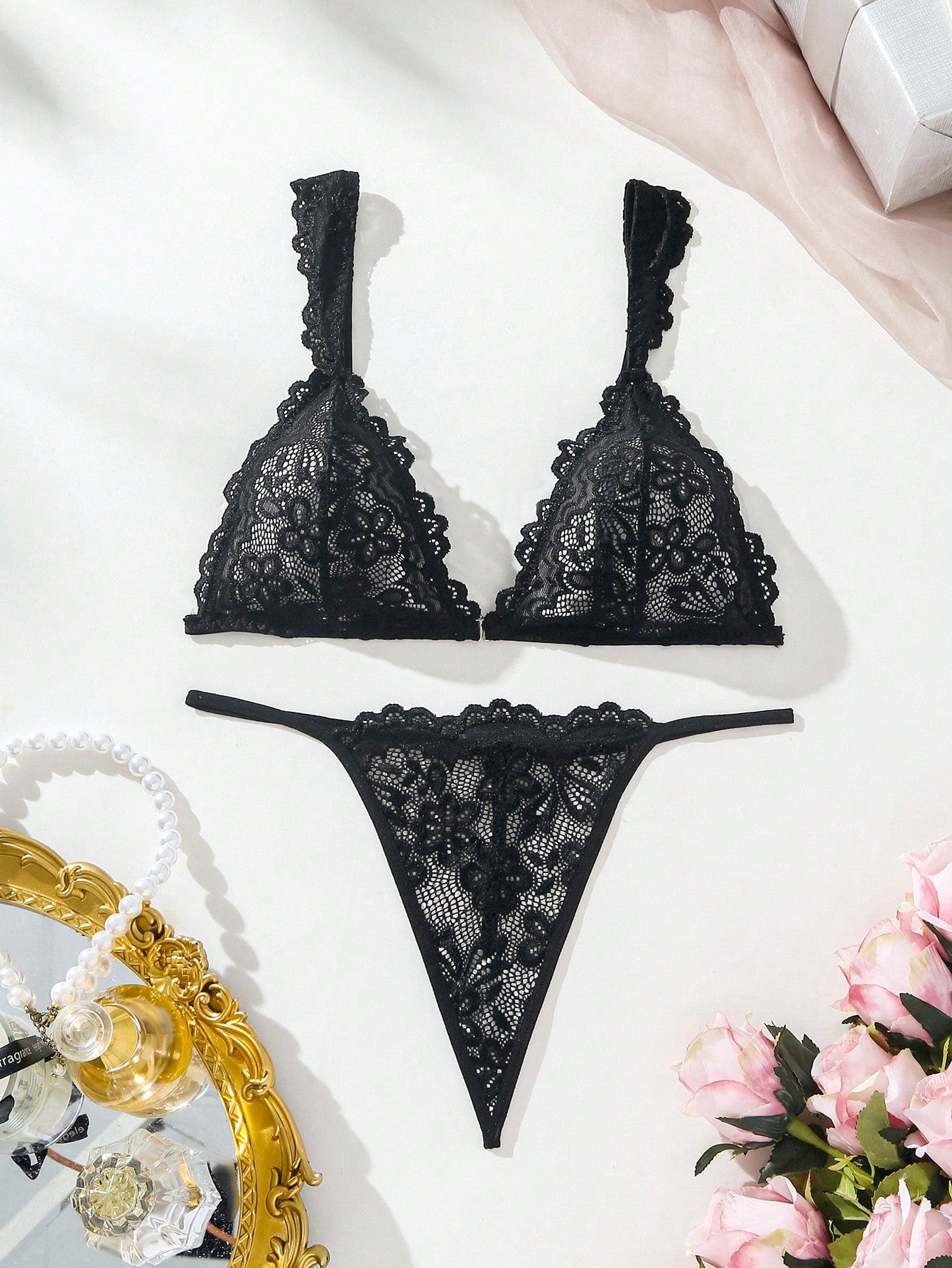 Black lace lingerie set featuring a triangle bra with adjustable spaghetti straps and matching mid-rise V-string thong briefs with scallop detailing and plant pattern.