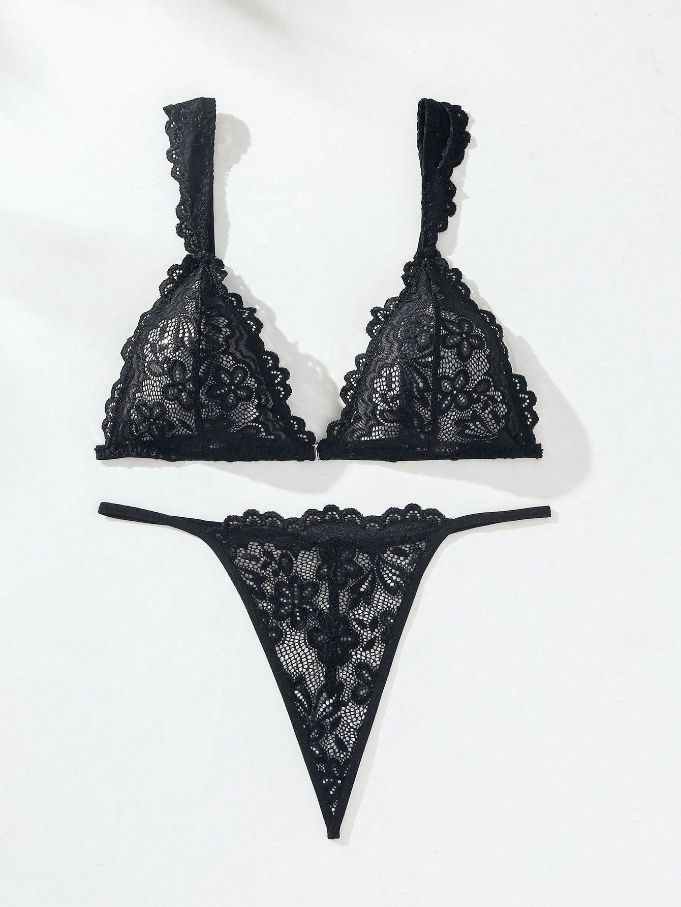 Black lace lingerie set featuring a triangle bra with adjustable spaghetti straps and matching mid-rise V-string thong briefs with scallop detailing and plant pattern.
