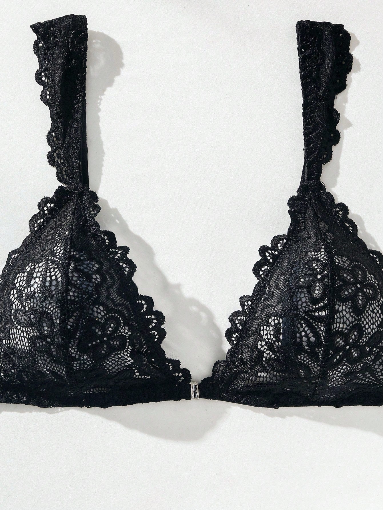 Black lace lingerie set featuring a triangle bra with adjustable spaghetti straps and matching mid-rise V-string thong briefs with scallop detailing and plant pattern.