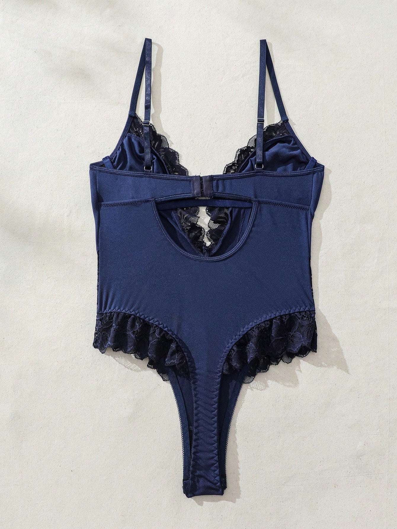 Women's lace bodysuit lingerie featuring a backless design, contrast lace, criss-cross detail, adjustable spaghetti straps, underwire full cups, and a high-rise thong fit.