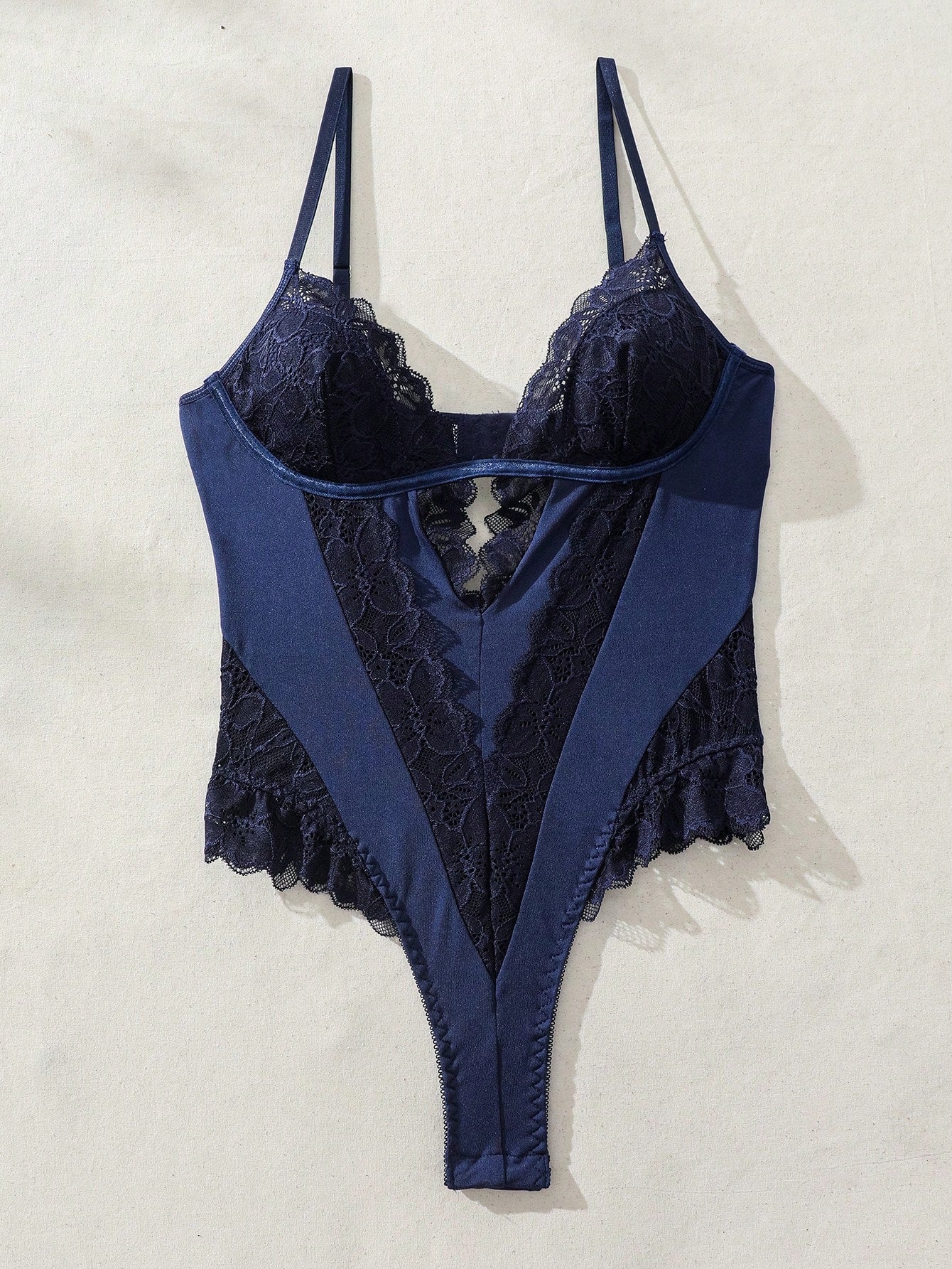 Women's lace bodysuit lingerie featuring a backless design, contrast lace, criss-cross detail, adjustable spaghetti straps, underwire full cups, and a high-rise thong fit.