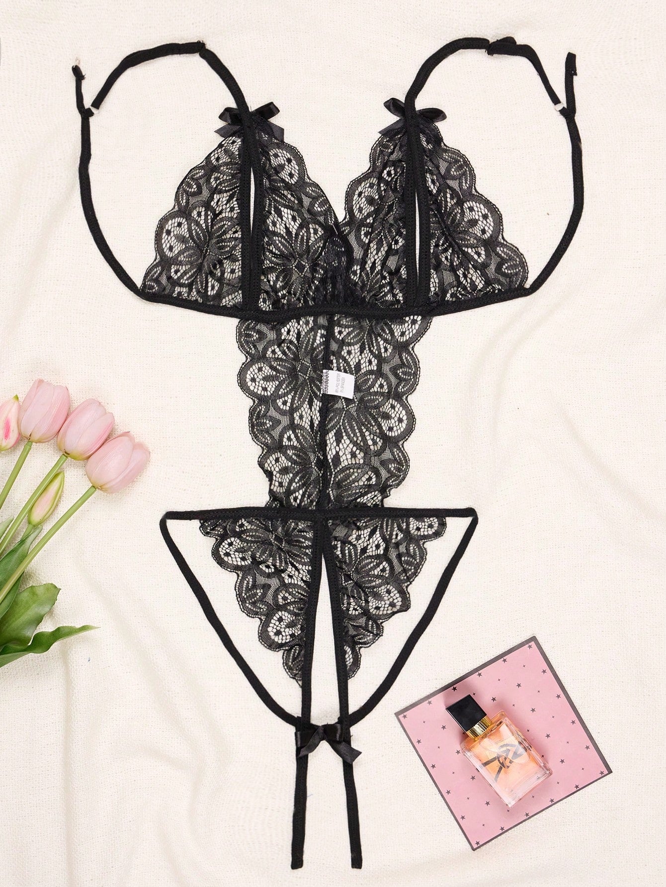 1-piece women’s lace bodysuit featuring an open crotch design, backless cut, exposed bust, underwire 1/2 cup bralette, adjustable spaghetti straps, thong back, and a body-shaping fit.