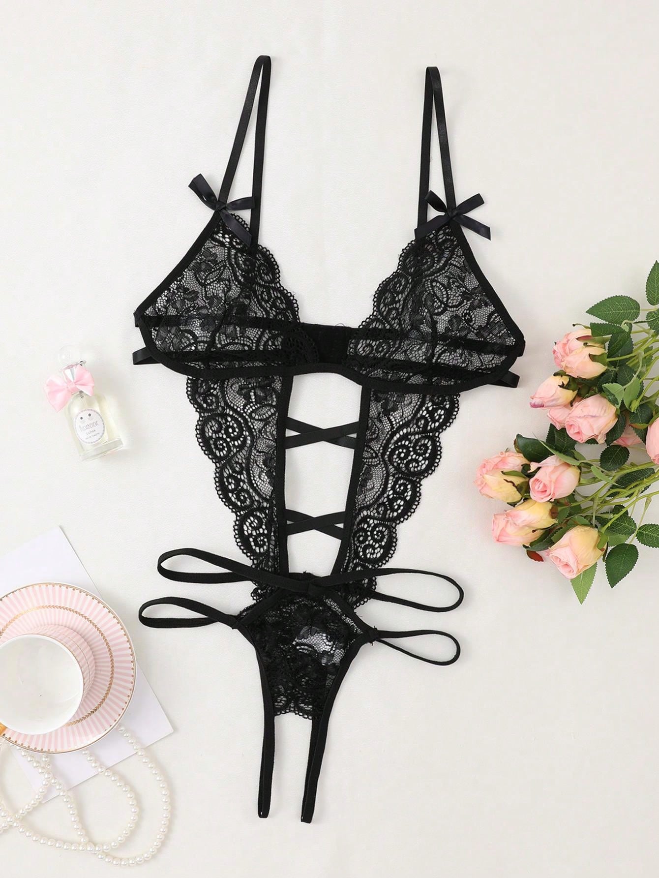 Women’s sexy lace bodysuit with bow detail, deep V neckline, spaghetti straps, backless cut, and open crotch thong design. Semi-sheer teddy style with contrast lace and cut-out details, available in black and white.