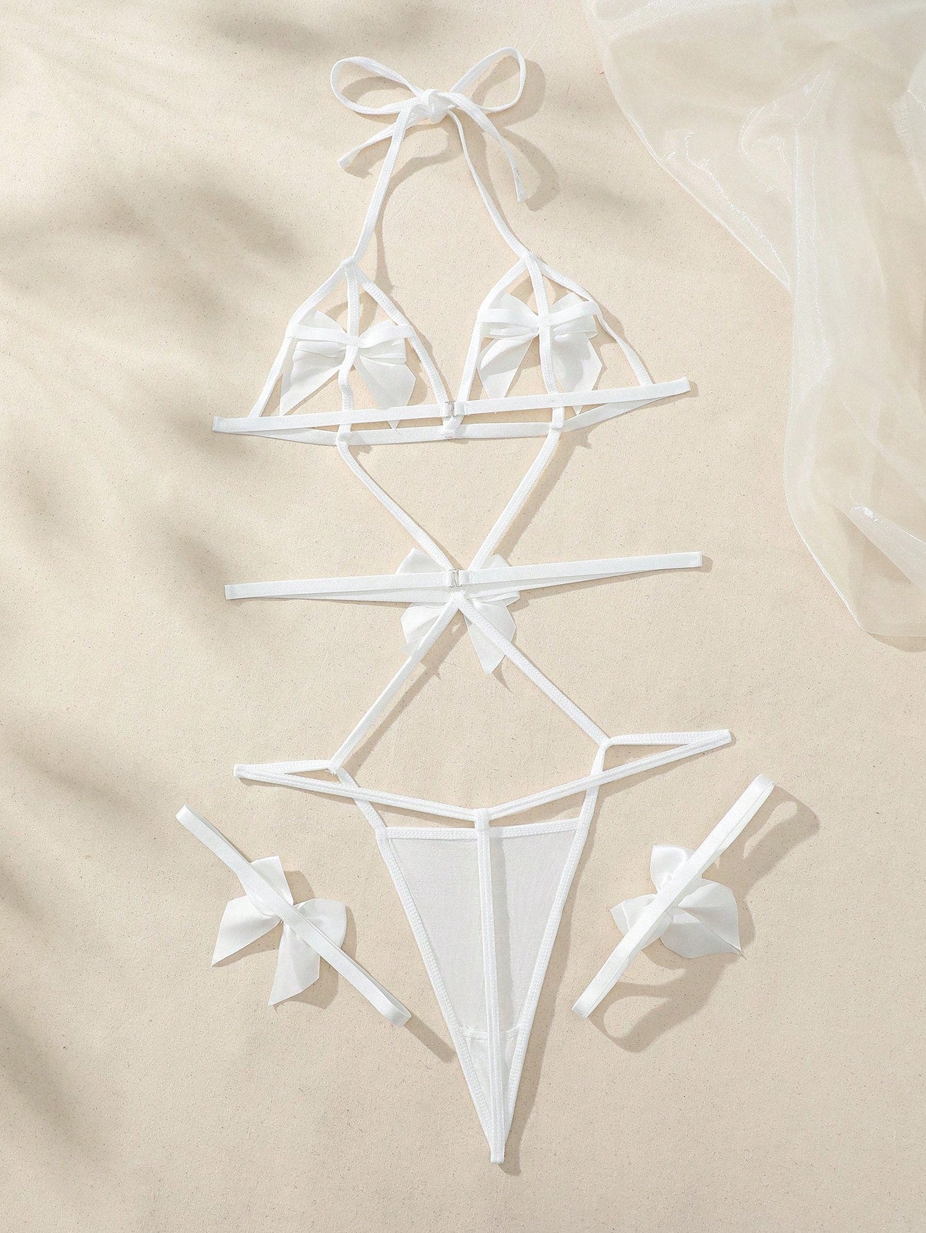 White women’s sexy bodysuit lingerie set with bowknot appliques and cut-out details, featuring adjustable spaghetti straps, underwire 1/2 cup teddy design, high-rise thong style, sleeveless semi-sheer knitted fabric.