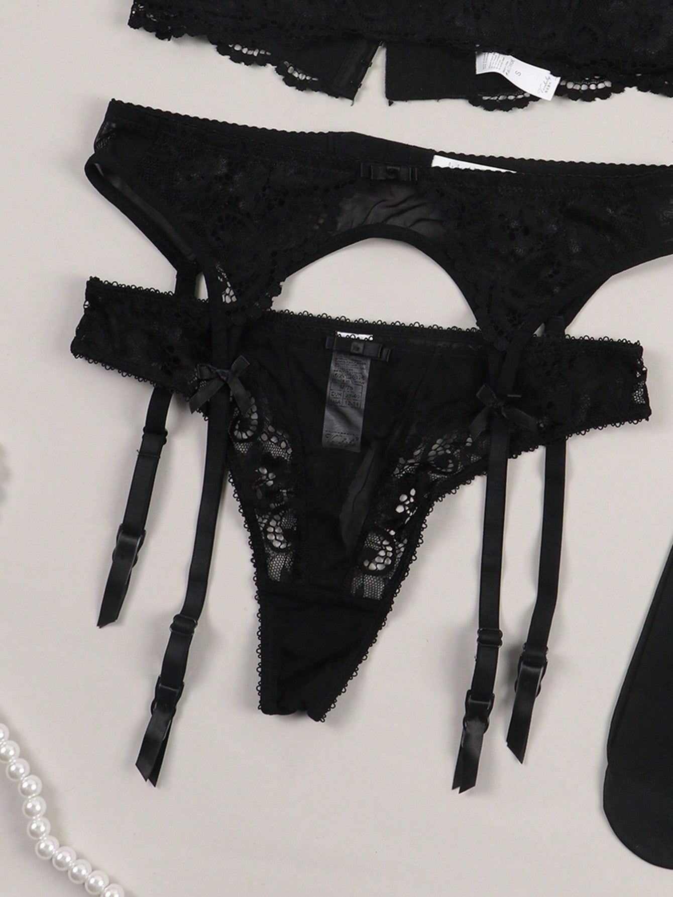Women’s floral lace garter lingerie 4-piece set with a plunge wireless bra, adjustable straps, low-rise hipster panty, and cut-out details.