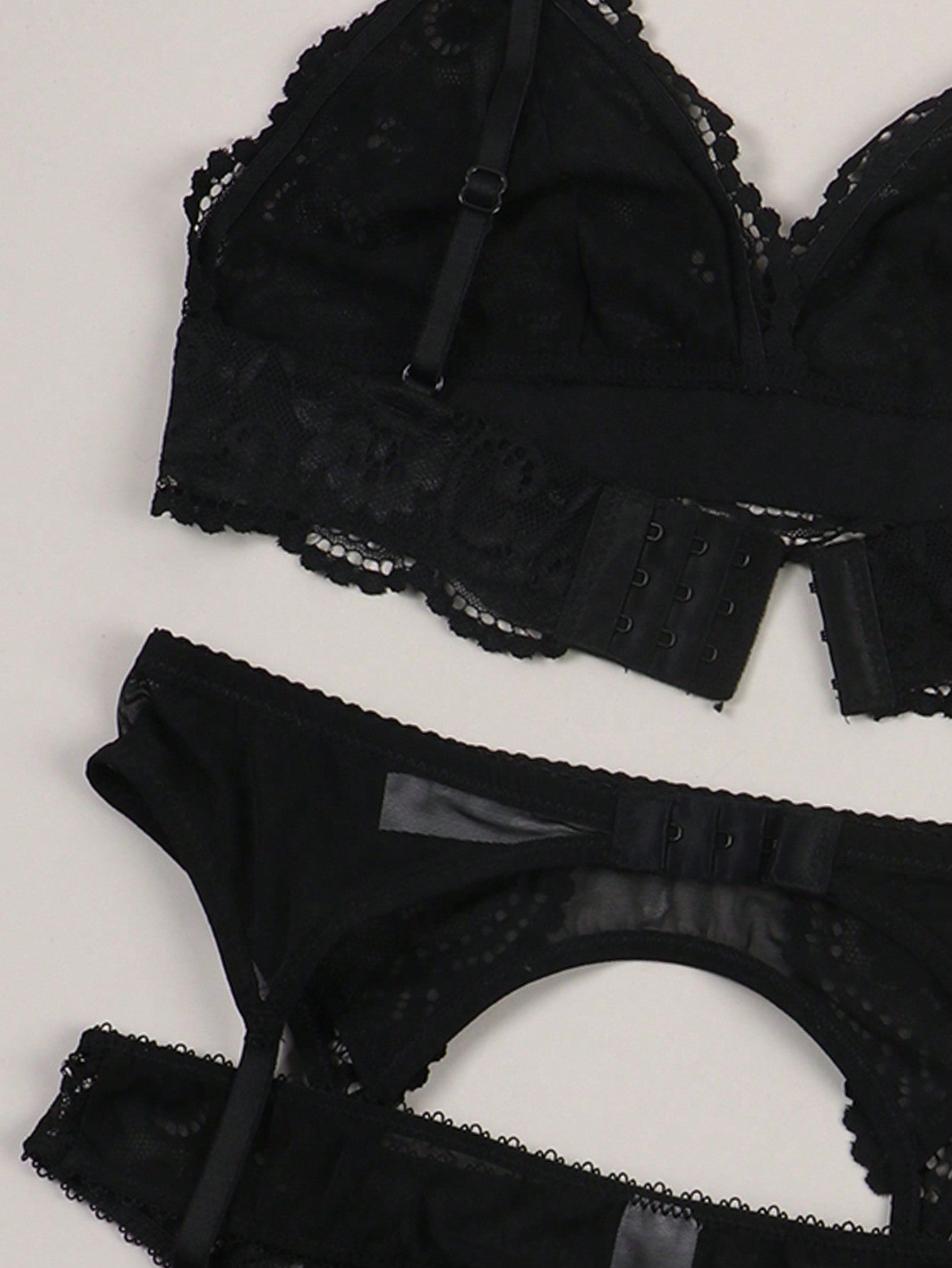 Women’s floral lace garter lingerie 4-piece set with a plunge wireless bra, adjustable straps, low-rise hipster panty, and cut-out details.