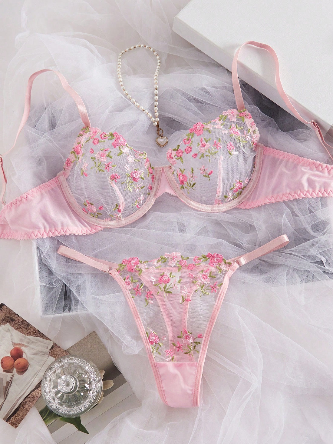 Women's floral embroidered sheer mesh lingerie set featuring a spaghetti strap camisole-style bralette with adjustable straps and a matching low-rise thong.