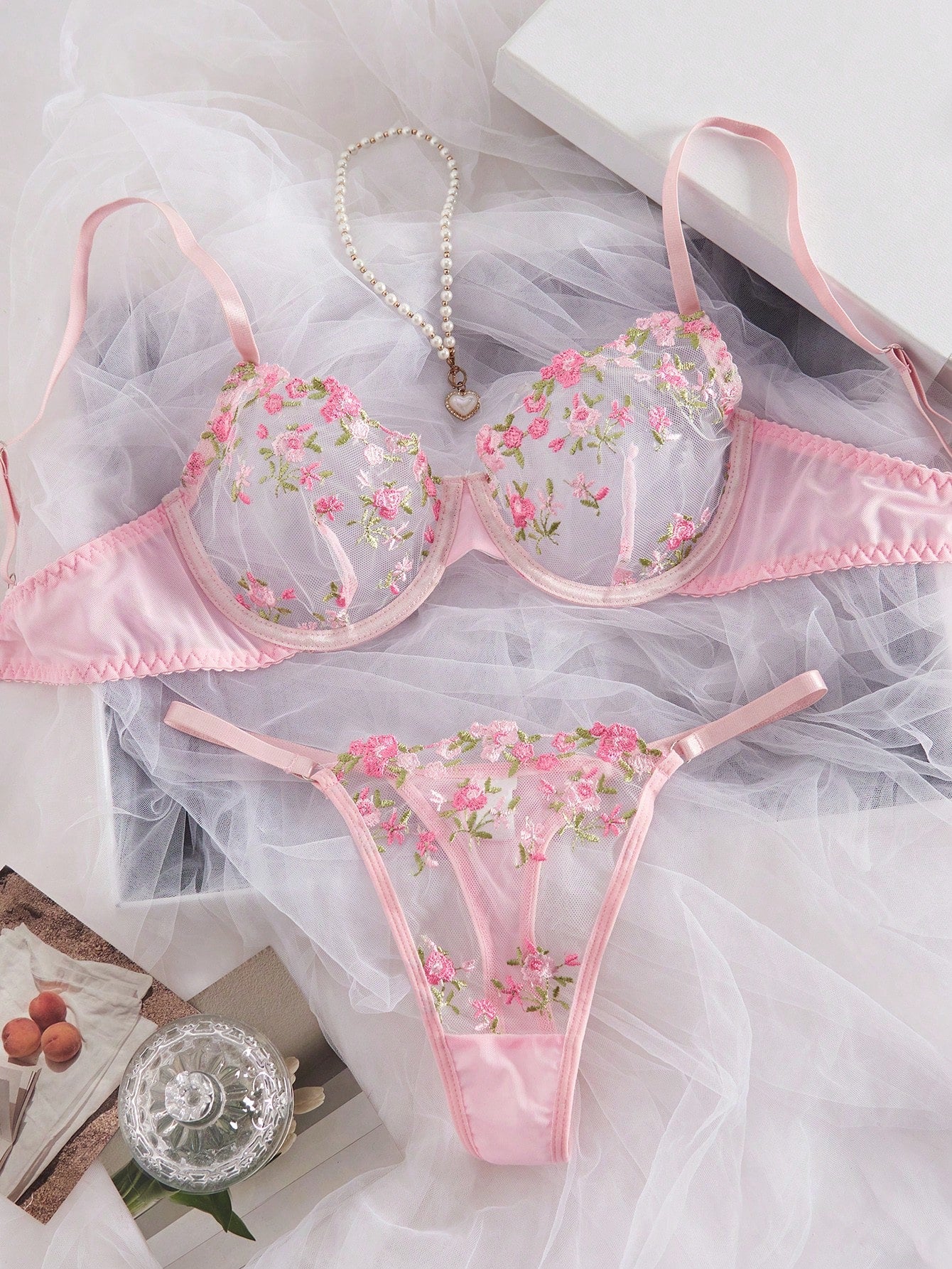 Women's floral embroidered sheer mesh lingerie set featuring a spaghetti strap camisole-style bralette with adjustable straps and a matching low-rise thong.
