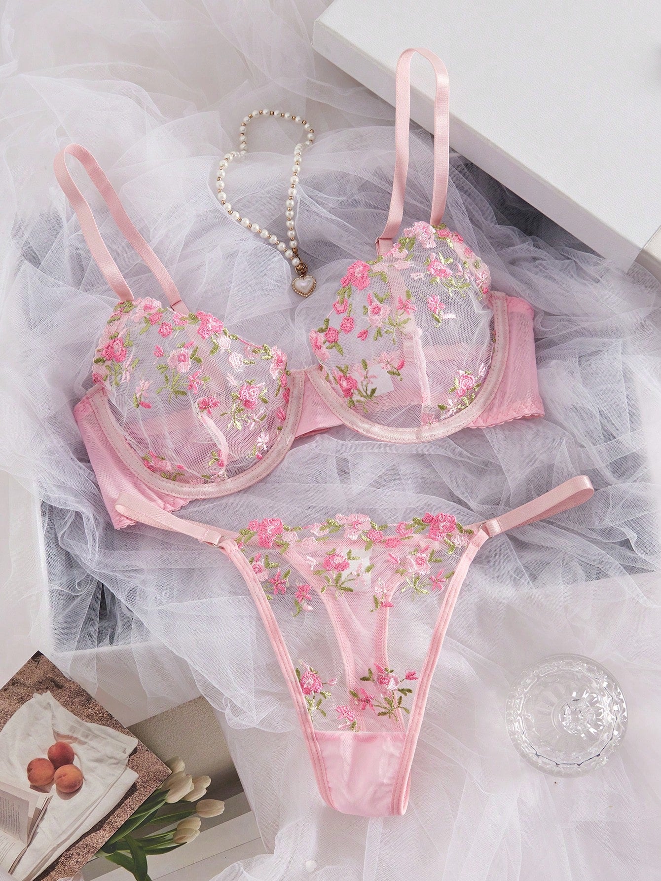 Women's floral embroidered sheer mesh lingerie set featuring a spaghetti strap camisole-style bralette with adjustable straps and a matching low-rise thong.