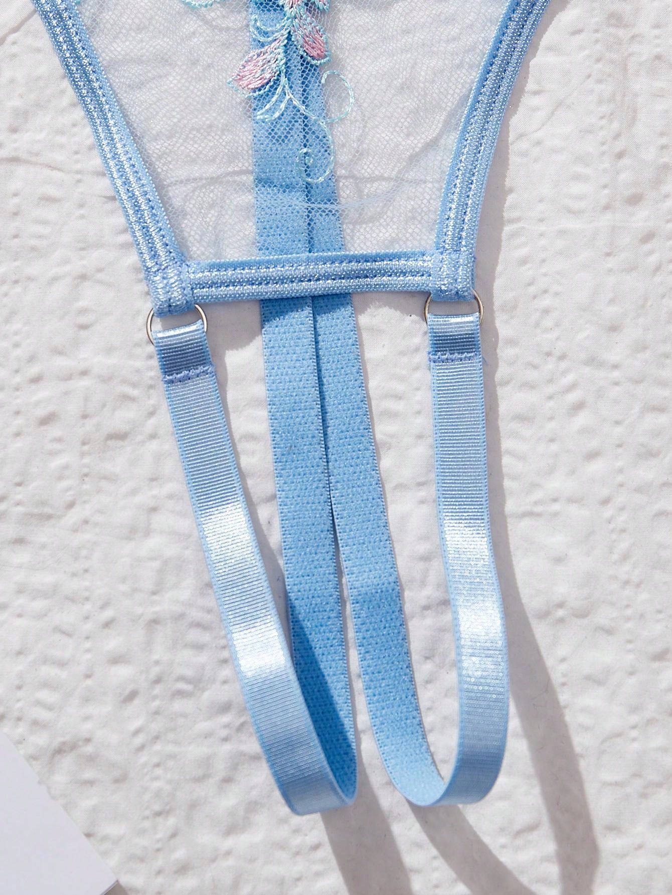 Two-piece women’s lingerie set with embroidered sheer fabric, hollow-out cutout details, underwire demi bra with adjustable spaghetti straps, and matching low-rise thong.