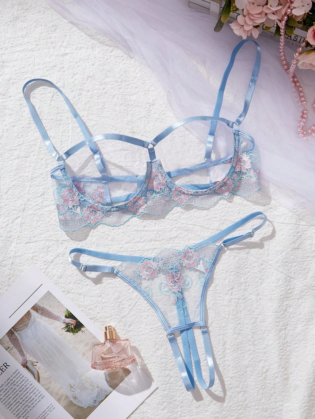 Two-piece women’s lingerie set with embroidered sheer fabric, hollow-out cutout details, underwire demi bra with adjustable spaghetti straps, and matching low-rise thong.