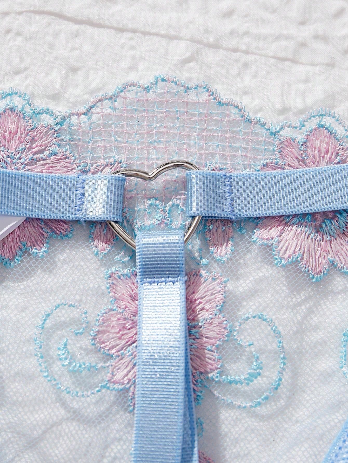 Two-piece women’s lingerie set with sheer embroidered details, cut-out accents, an underwire demi bra with adjustable spaghetti straps, and matching low-rise thong panties.