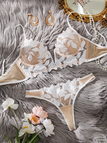 White 2-piece lingerie set with a French classic look, featuring an embroidered sheer underwire bralette with adjustable straps and a matching low-rise thong.