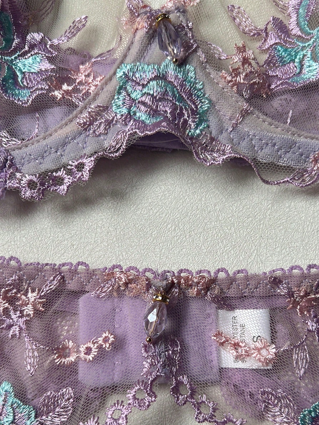 Women's romantic purple lingerie set with embroidered sheer bralette and matching thongs, featuring underwire support, triangle cups, and adjustable spaghetti straps in a 5-piece set.
