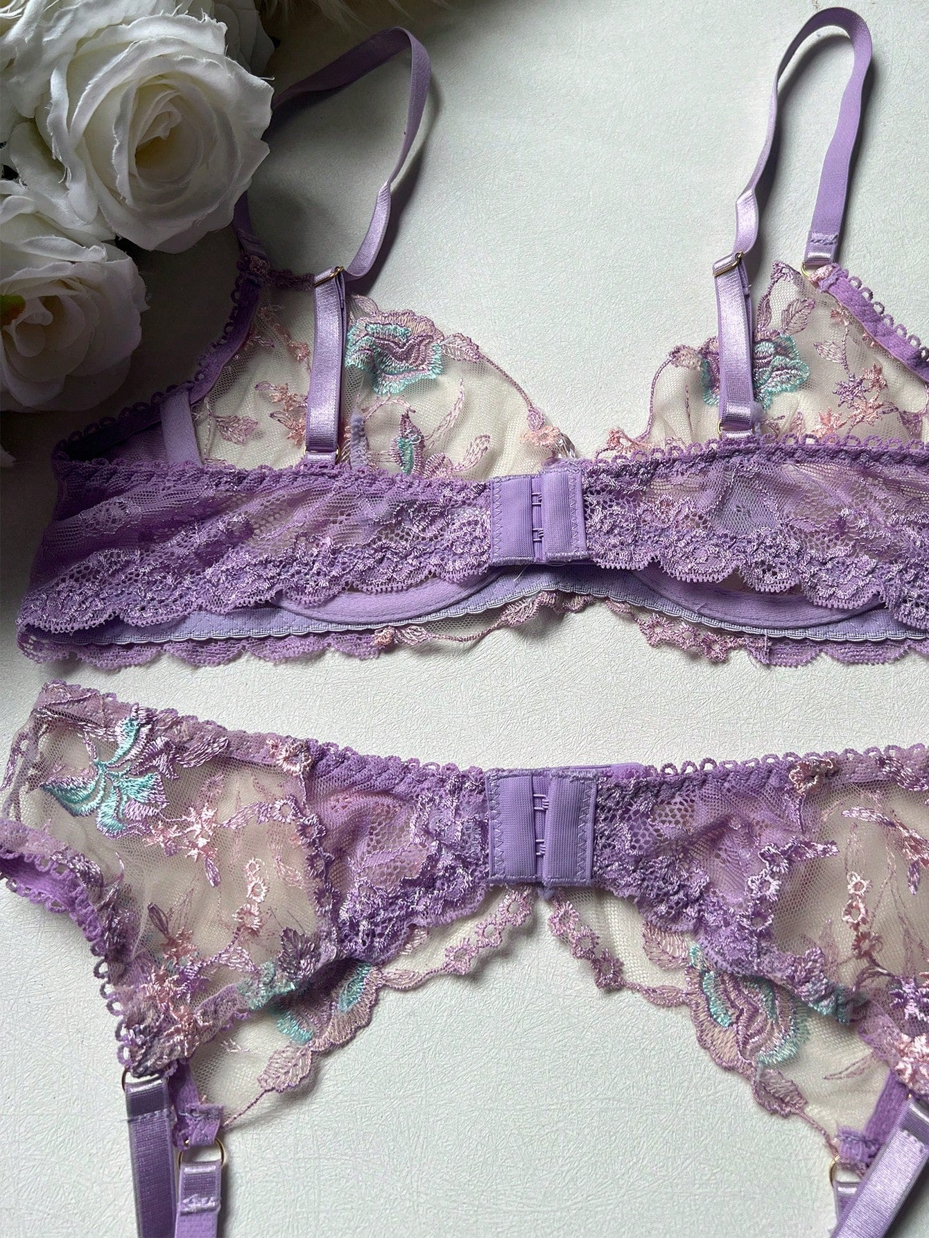 Women's romantic purple lingerie set with embroidered sheer bralette and matching thongs, featuring underwire support, triangle cups, and adjustable spaghetti straps in a 5-piece set.