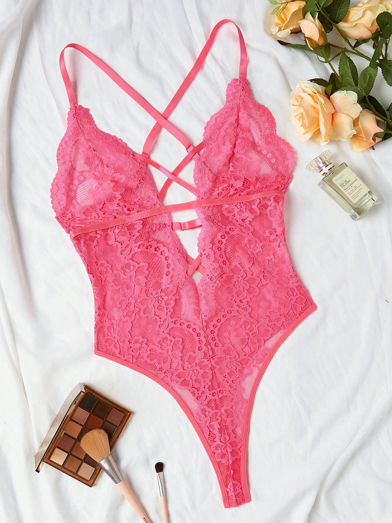 Women’s lace bodysuit featuring a criss-cross back, backless design, spaghetti straps, cut-out accents, and scalloped trim.