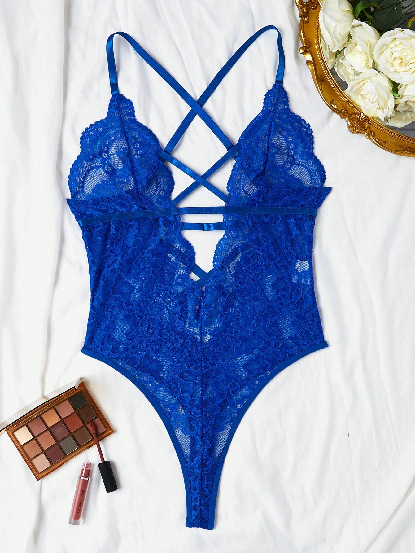 Women’s lace bodysuit featuring a criss-cross back, backless design, spaghetti straps, cut-out accents, and scalloped trim.