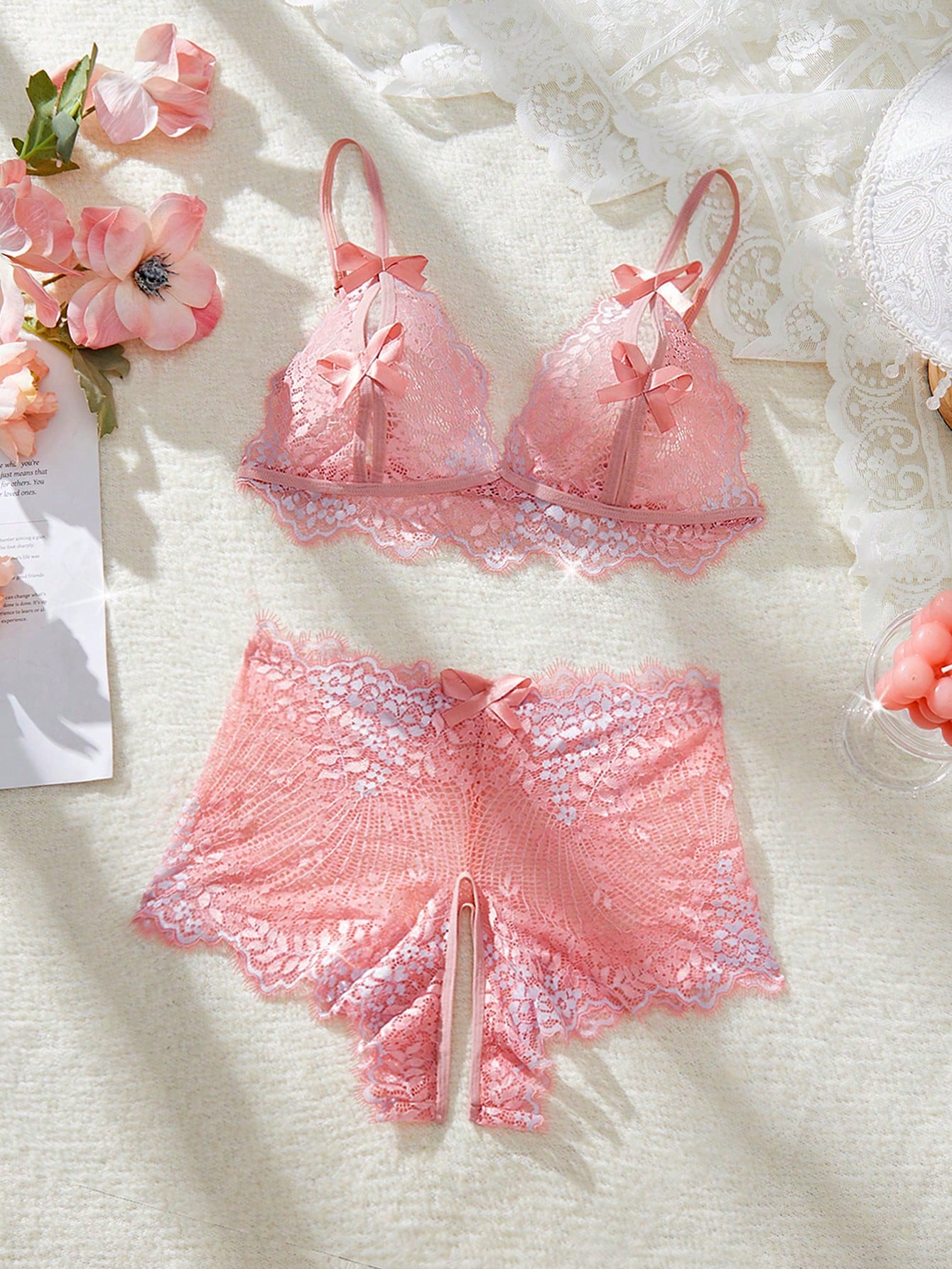 Pink 2-piece women’s lace lingerie set featuring a wireless bralette with adjustable spaghetti straps and matching open-crotch boyshort panties with scallop trim, sheer cutout details, and slight stretch.