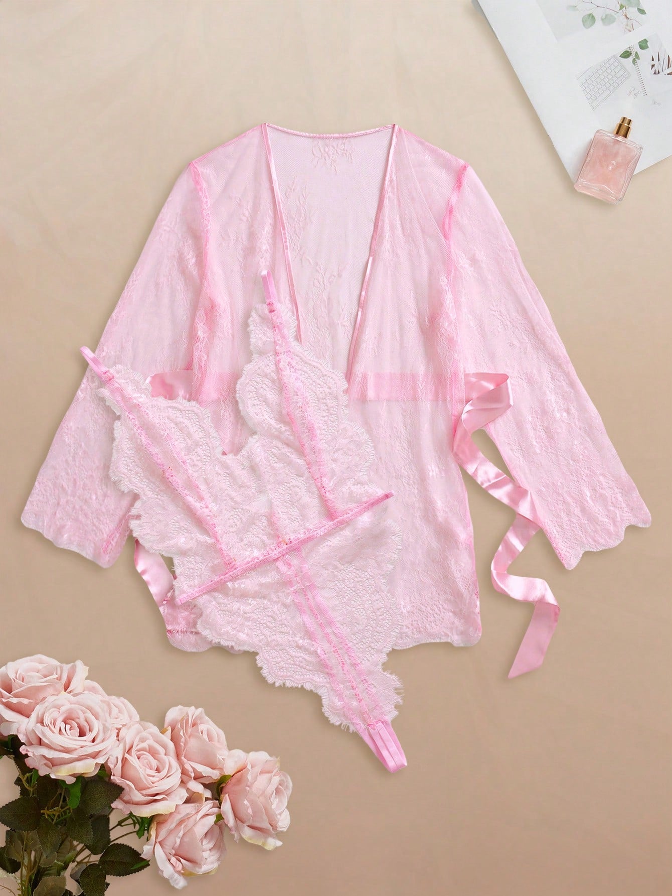 Two-piece women’s lingerie set featuring a floral lace plunging teddy bodysuit with adjustable spaghetti straps and a matching short belted robe with long sleeves and semi-sheer lace detail.