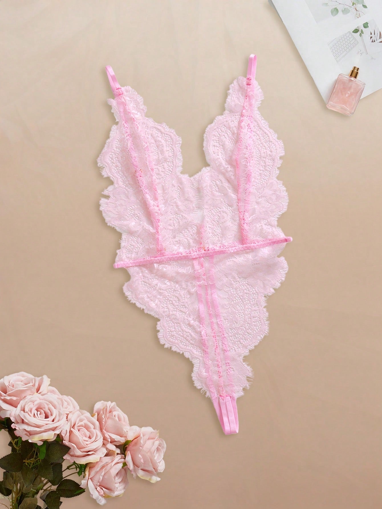 Two-piece women’s lingerie set featuring a floral lace plunging teddy bodysuit with adjustable spaghetti straps and a matching short belted robe with long sleeves and semi-sheer lace detail.