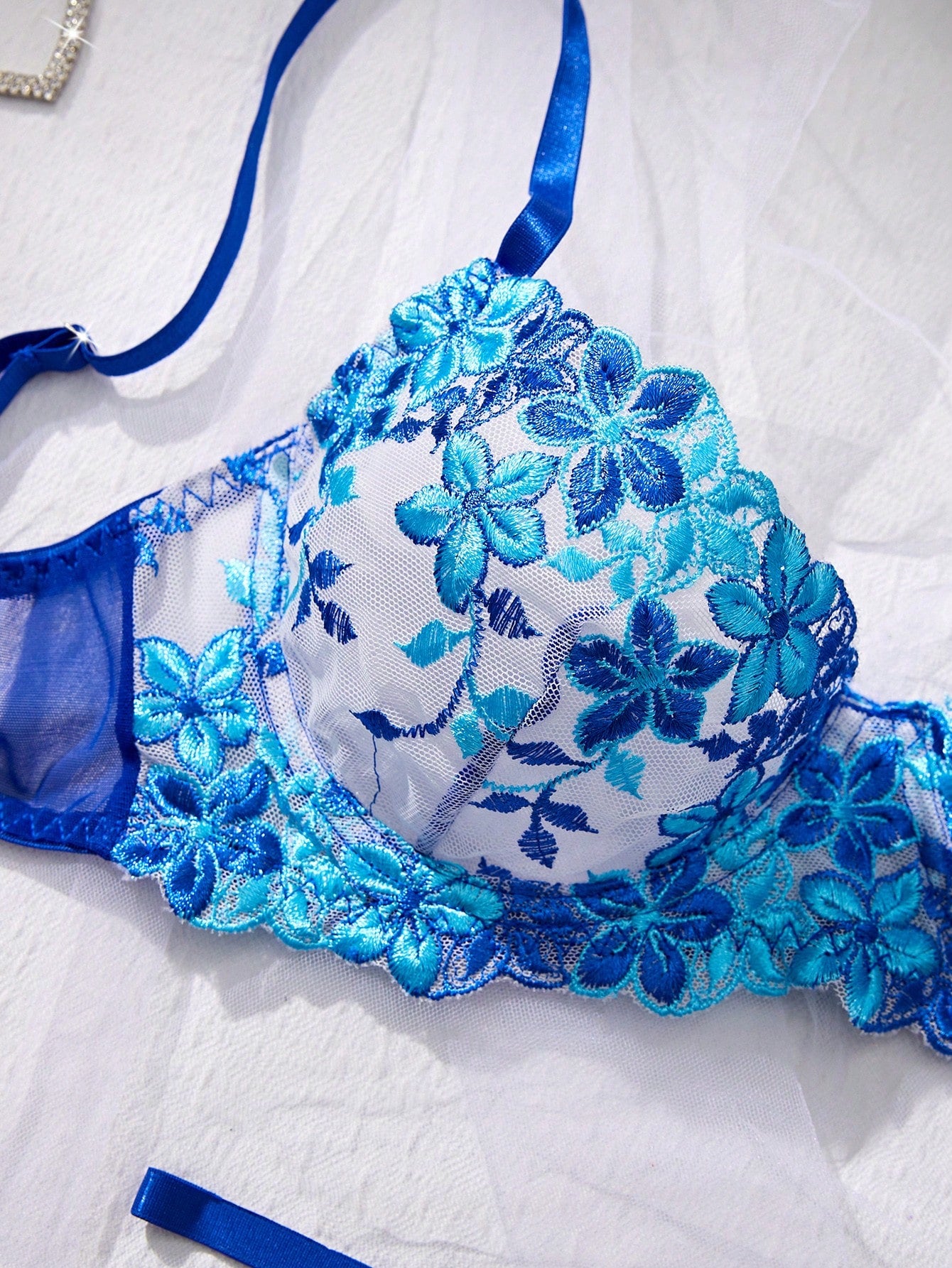 Three-piece women’s sexy lingerie set featuring floral embroidery and sheer details, with a spaghetti strap underwire bralette and matching low-rise briefs.