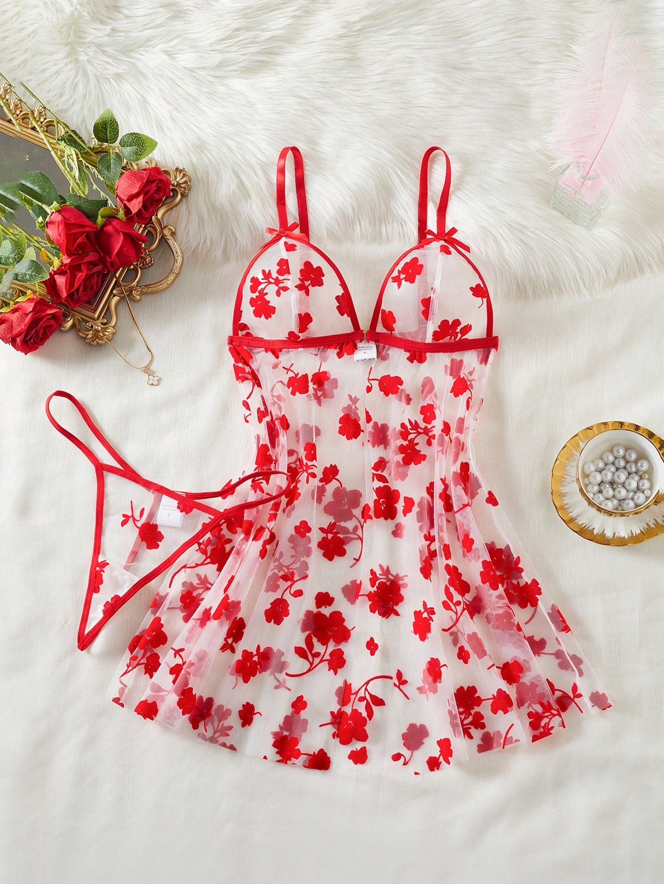 Two-piece women’s floral mesh sleepwear set featuring a front-clasp sheer embroidered bralette with adjustable spaghetti straps and a matching low-rise thong.