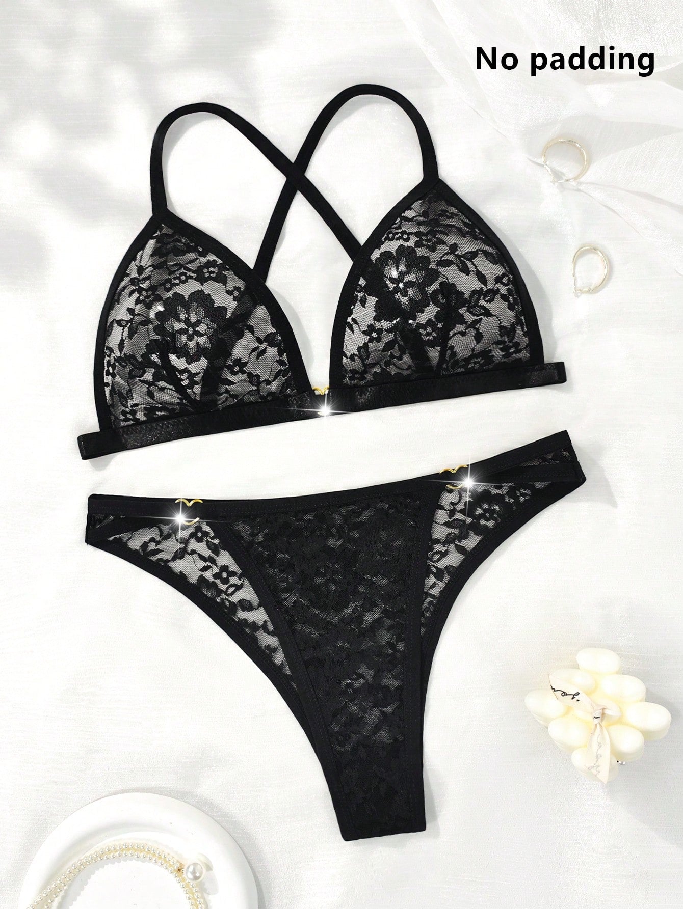 Black 2-piece floral lace lingerie set with sheer cut-out details, a heart ring accent, adjustable spaghetti straps, a bralette top, and a low-rise thong.