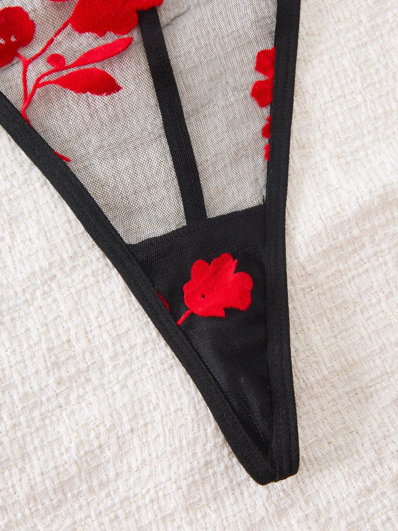 Two-piece women’s floral mesh sleepwear set featuring a front-clasp sheer embroidered bralette with adjustable spaghetti straps and a matching low-rise thong.