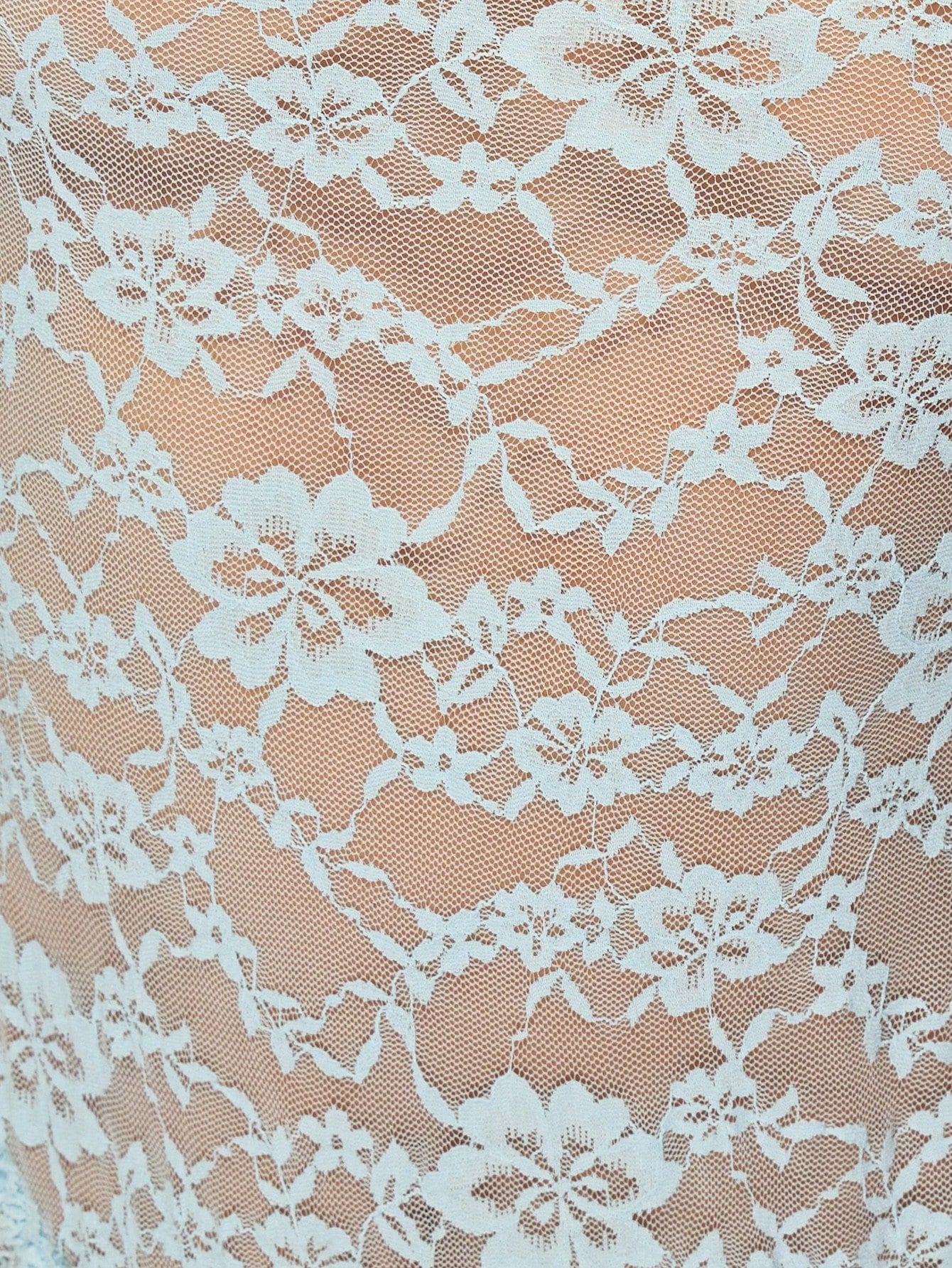 Blue semi-sheer floral lace bodysuit teddy with cap sleeves, sweetheart neckline, backless design, high-cut leg, thong back, scalloped trim, and adjustable straps.