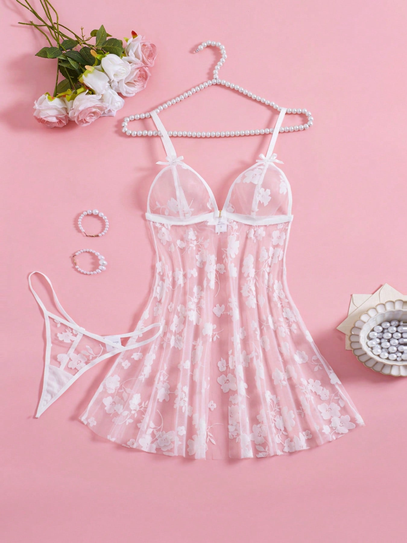 Blue 2-piece women’s lingerie set with floral print mesh and embroidery details, featuring a front-closure spaghetti strap babydoll with adjustable straps and a matching low-rise thong; semi-sheer, sleeveless, and wireless design.