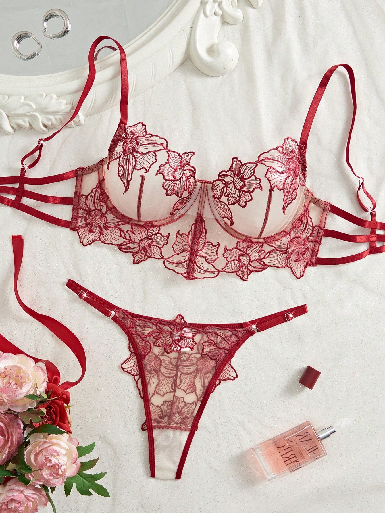 Two-piece women’s lingerie set with a sheer balconette underwire bra featuring adjustable straps and matching low-rise thong panty with embroidery and cut-out details.