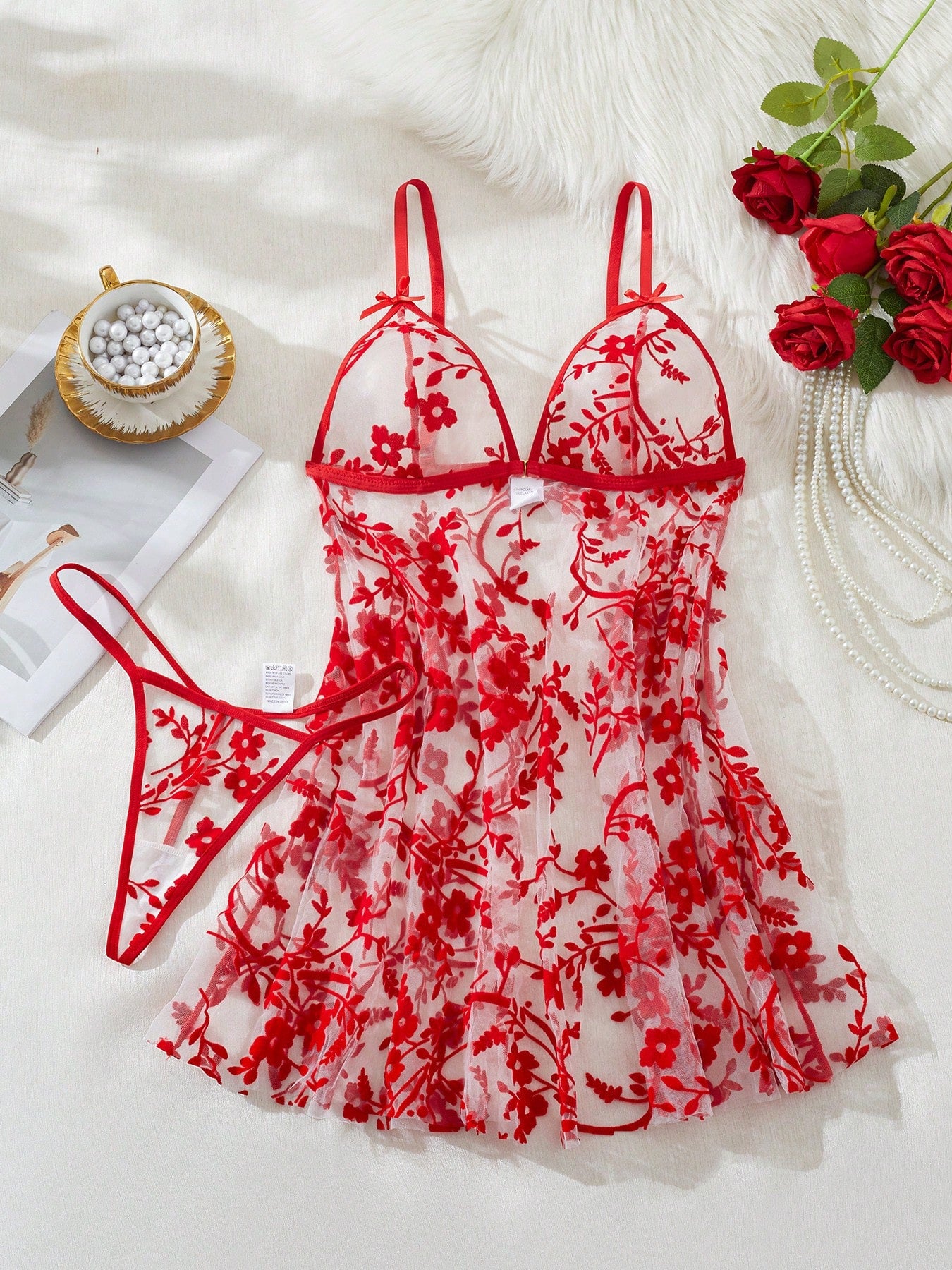 Blue 2-piece women’s lingerie set with floral print mesh and embroidery details, featuring a front-closure spaghetti strap babydoll with adjustable straps and a matching low-rise thong; semi-sheer, sleeveless, and wireless design.