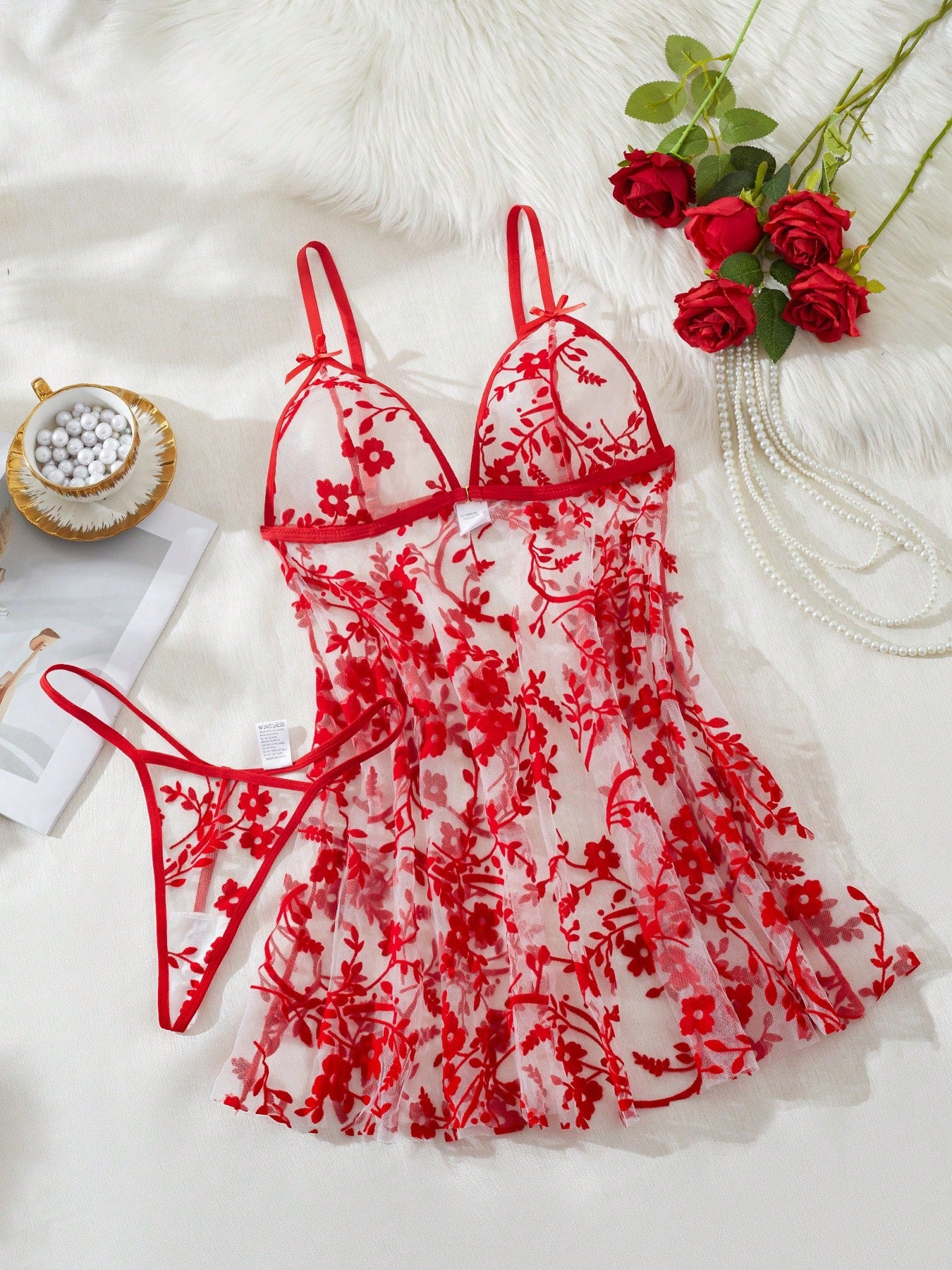 Two-piece women’s floral mesh sleepwear set featuring a front-clasp sheer embroidered bralette with adjustable spaghetti straps and a matching low-rise thong.